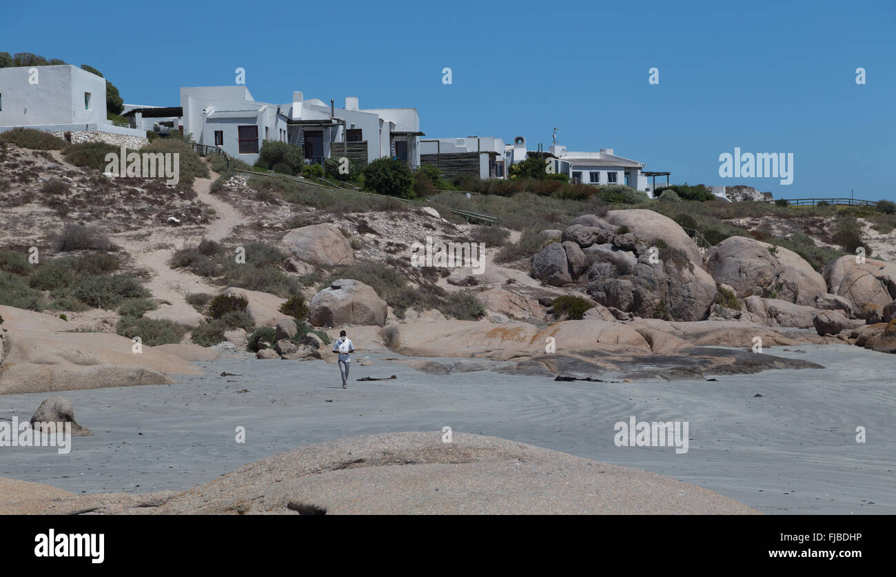 Houses perch on the beach edge close to granite boulders in the seaside paradise of Paternoster, Northern Cape, South Africa Stock Photo