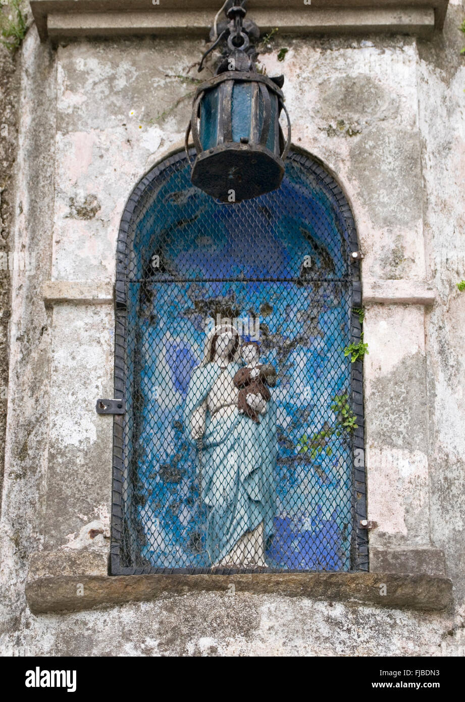 Virgin and Child statue in a niche with grid, Italy Stock Photo