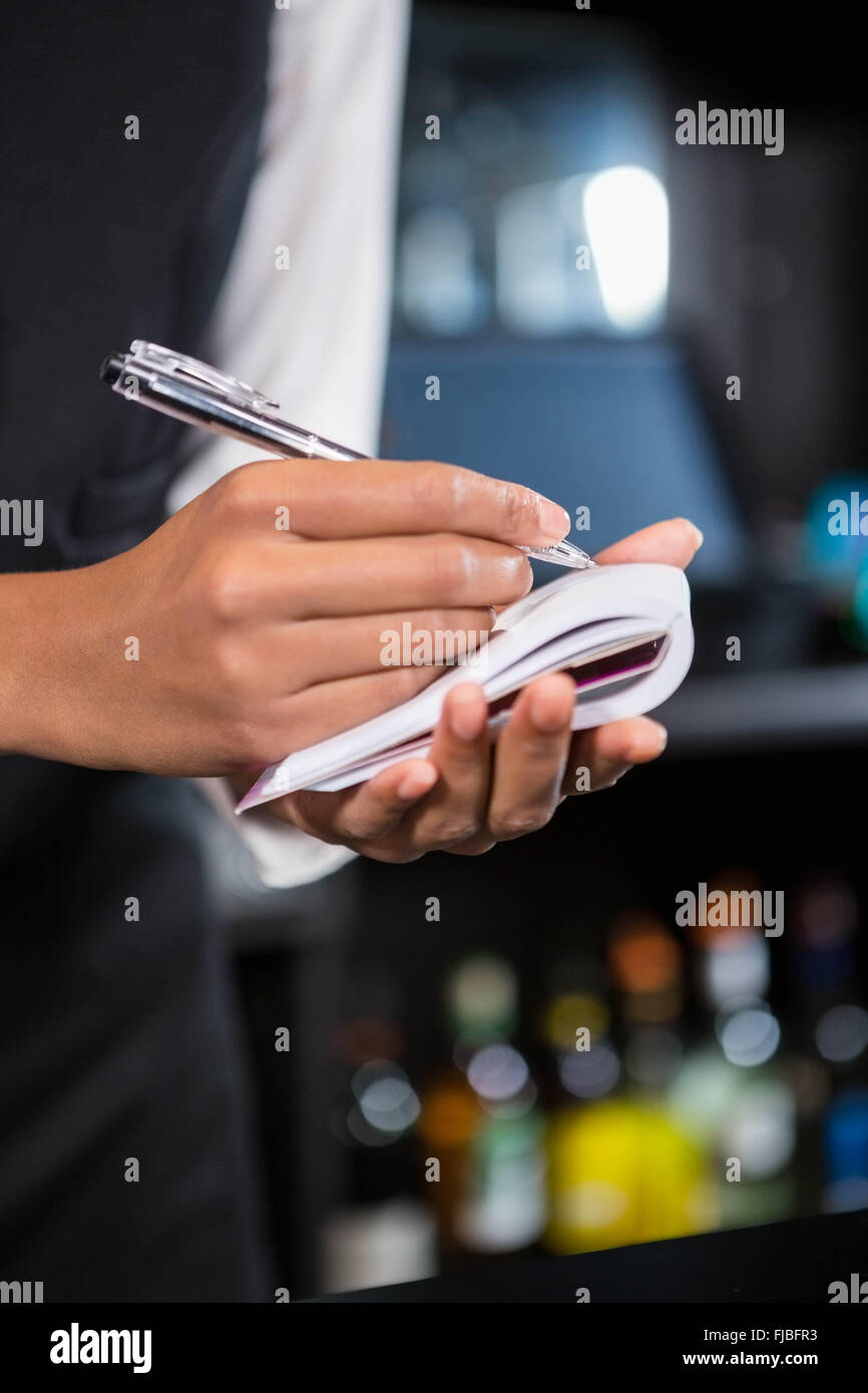 Bartender writing down an order Stock Photo