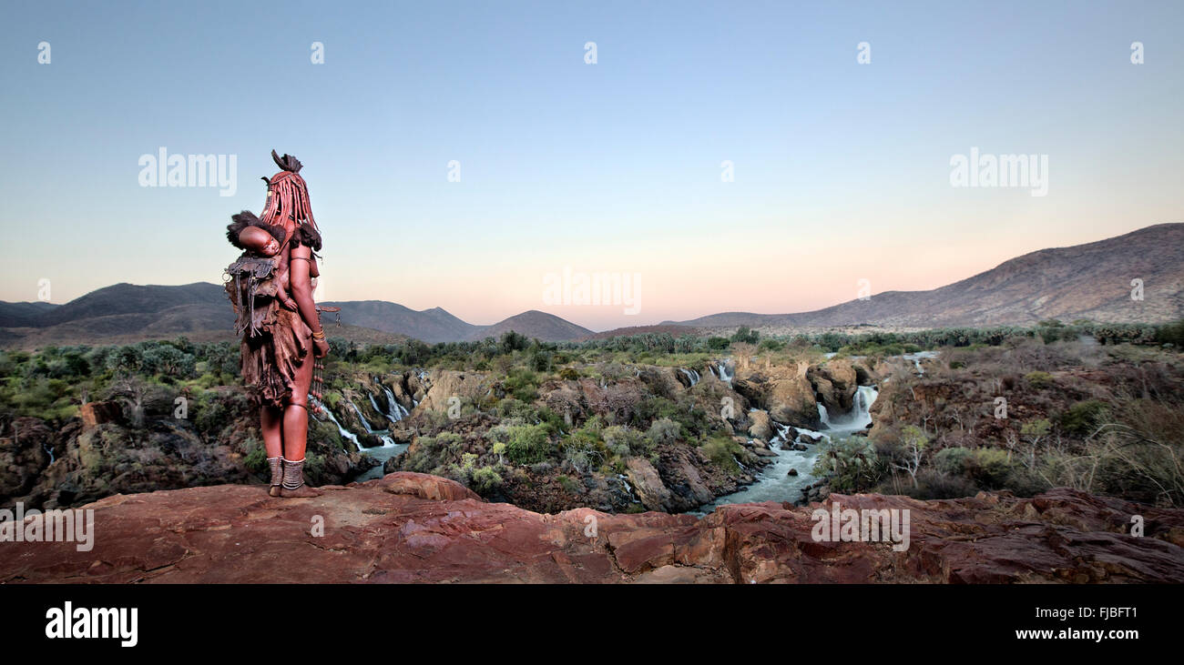 Himba woman overlooking Epupa Falls. Stock Photo