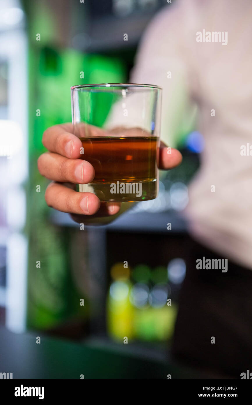 Bartender serving a glass of whiskey Stock Photo