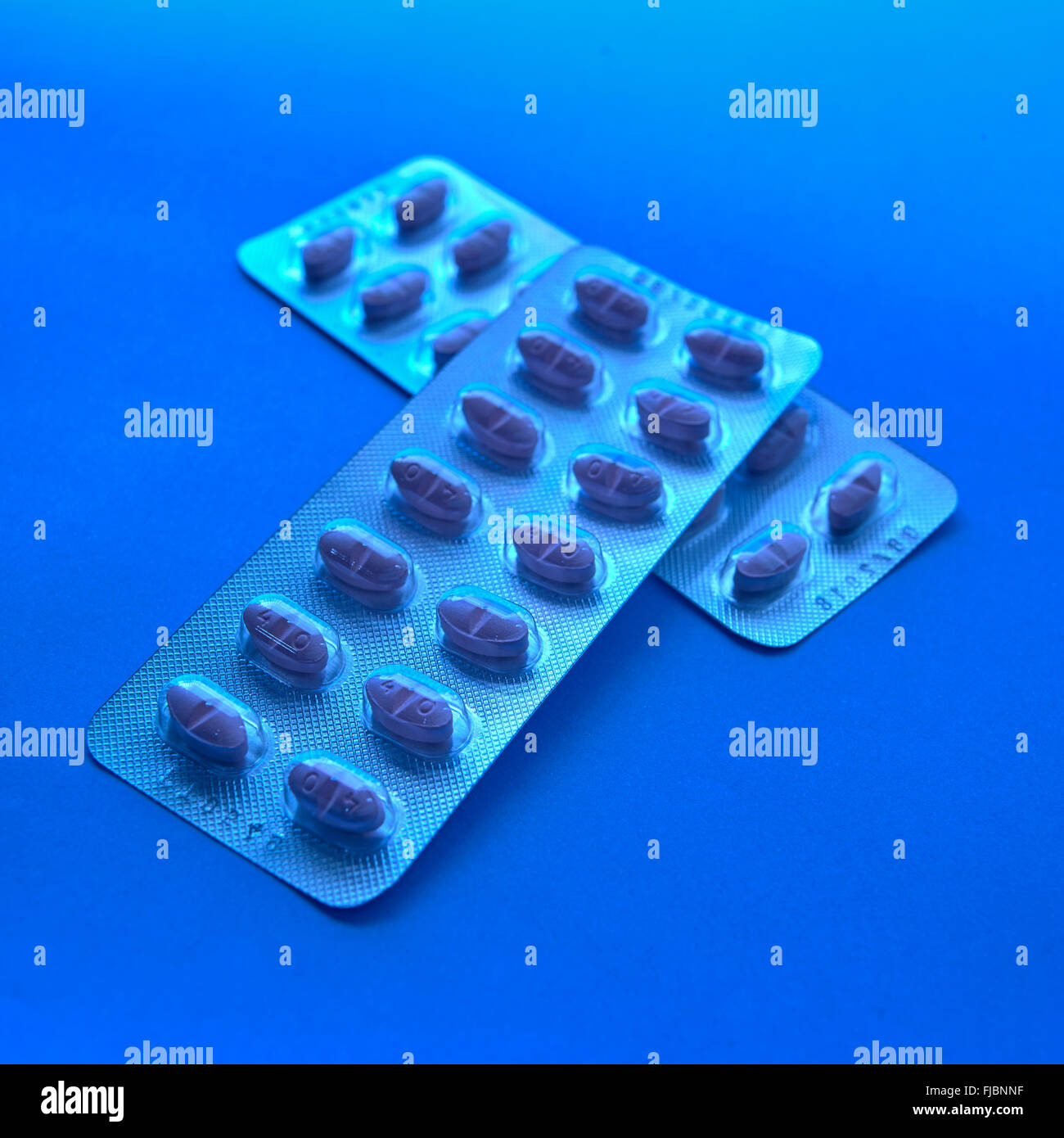 Statins, cholesterol lowering drugs, in blister packaging on blue background Stock Photo