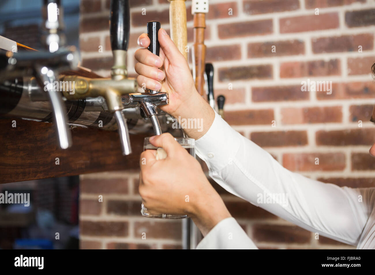 Masculine hands pouring beer Stock Photo
