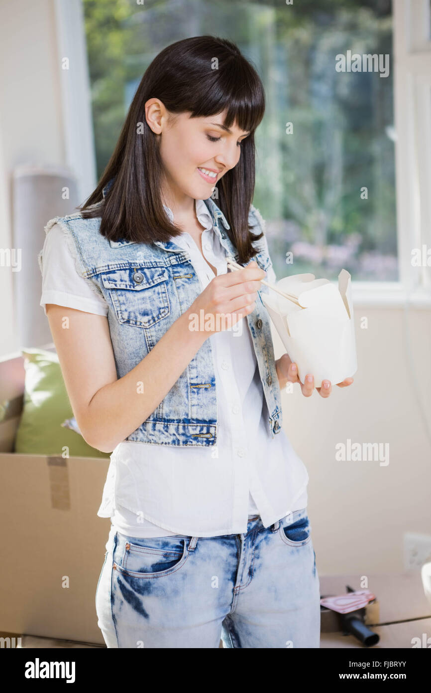 Young woman eating noodles at home Stock Photo