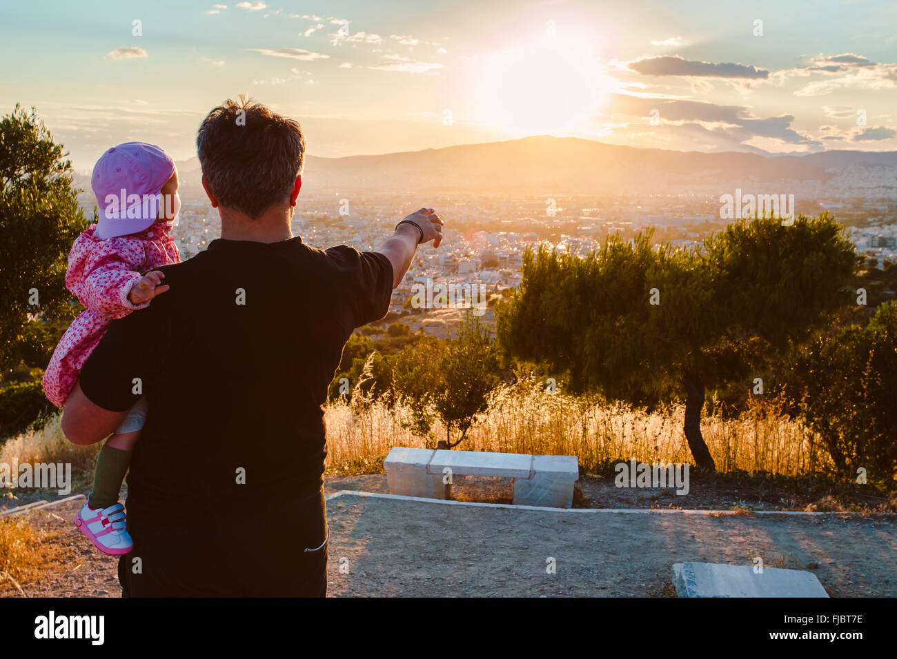 father holding his baby looking to the sunset Stock Photo