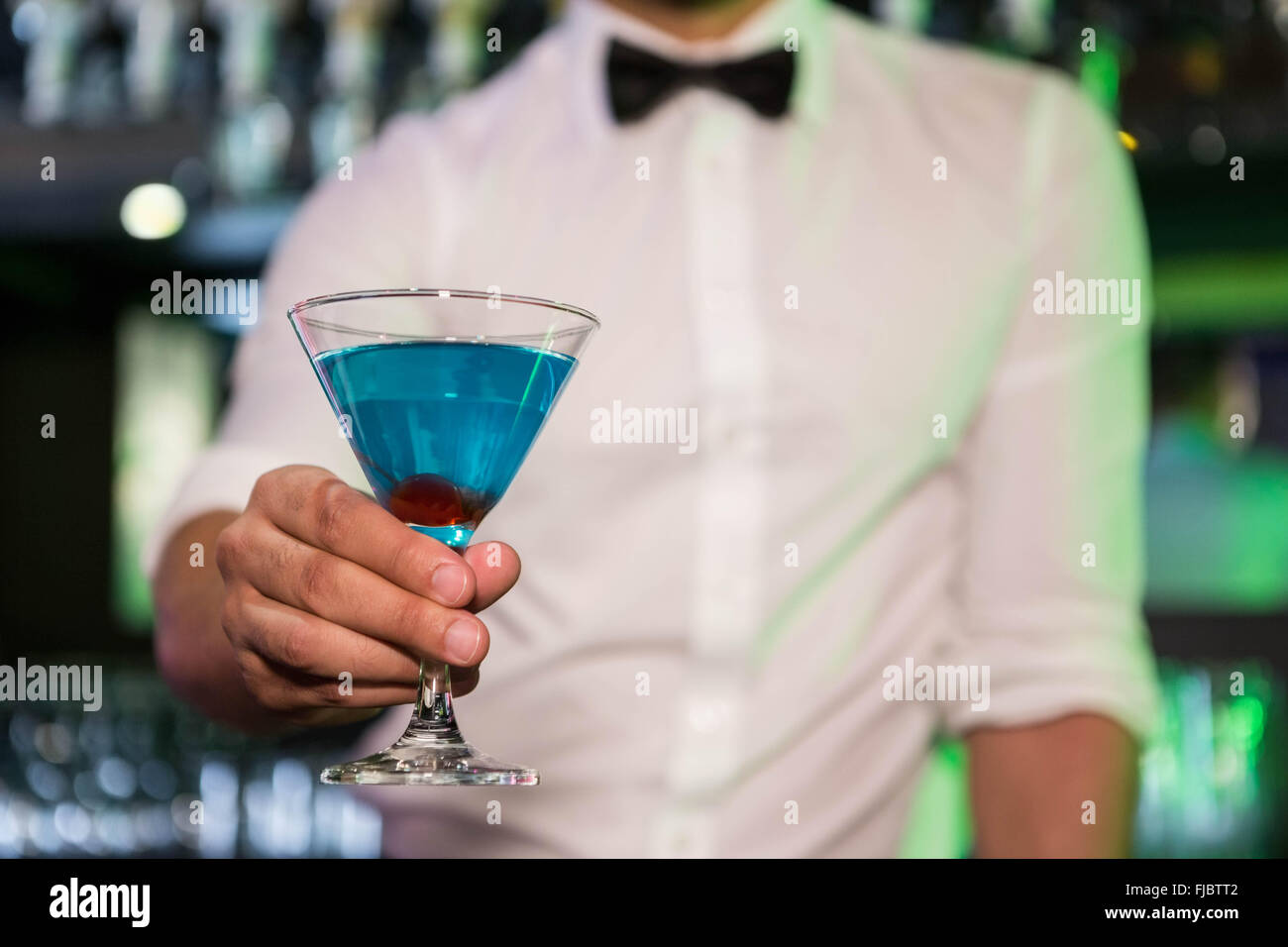 Bartender serving a blue martini Stock Photo