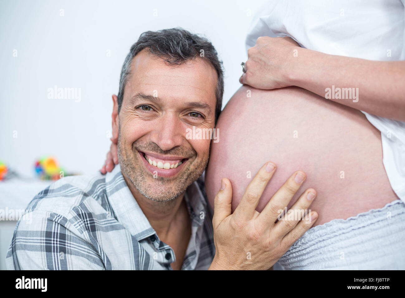 Man listening the belly of pregnant woman Stock Photo - Alamy