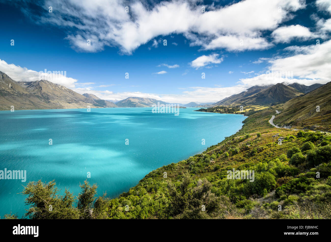 Blue sky with clouds over turquoise lake, Lake Wakatipu, right Glenorchy-Queenstown Road, New Zealand, South Island Stock Photo