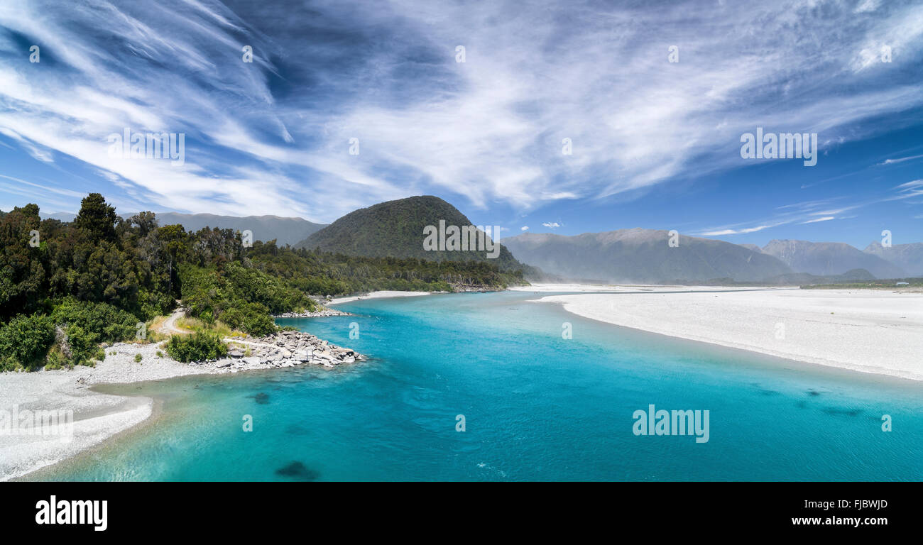 Turquoise river bed of the Haast River, Haast, behind mountains of the Mount Aspiring National Park, West Coast, South Island Stock Photo