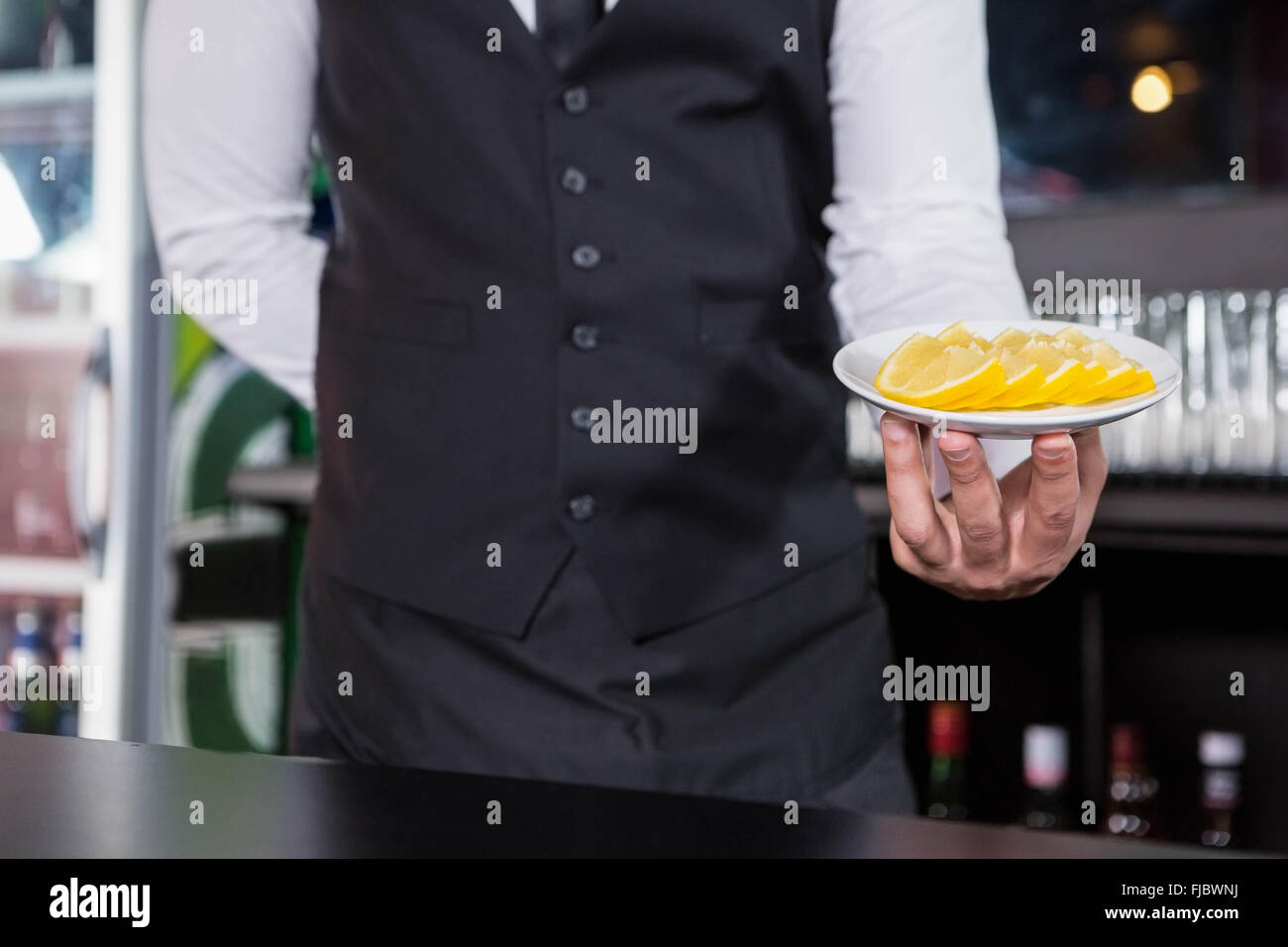 Waiter serving slices of lime Stock Photo