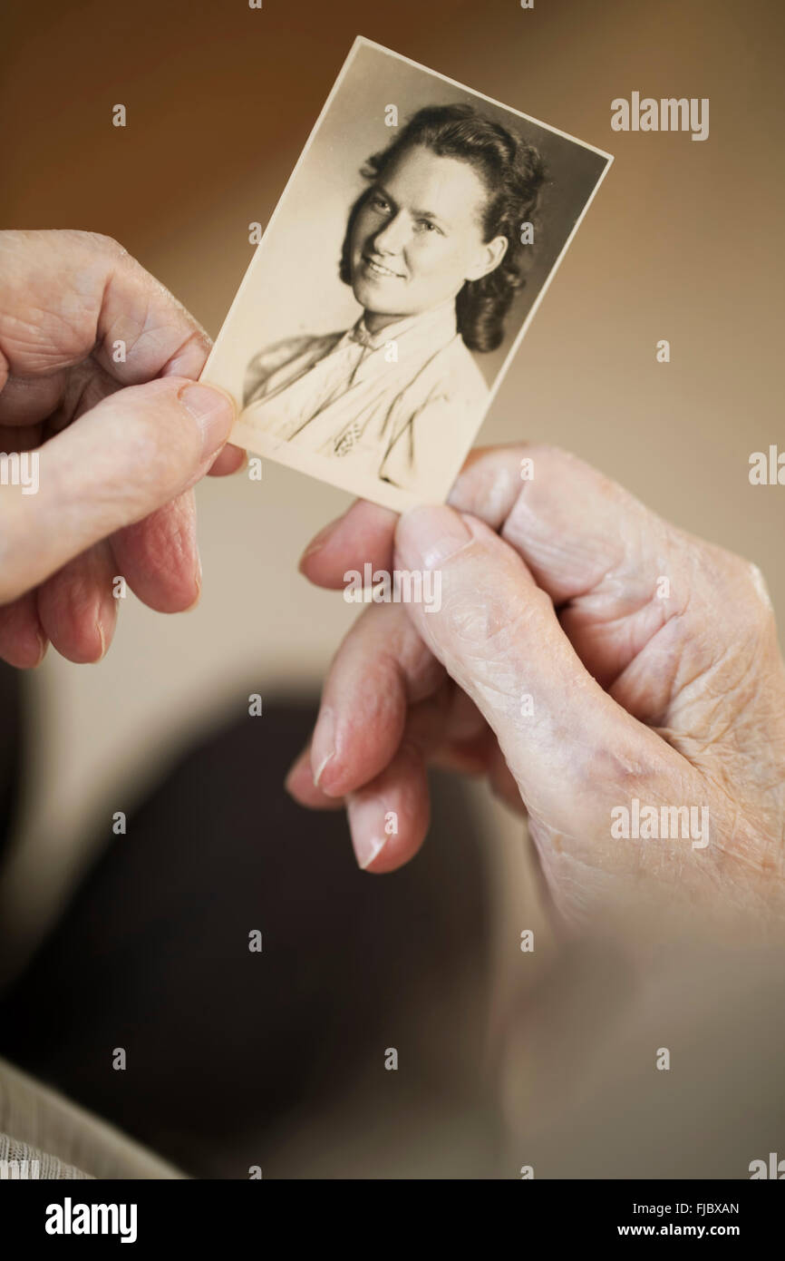 Hands of an old woman holding a photo, portrait from her youth, North Rhine-Westphalia, Germany Stock Photo