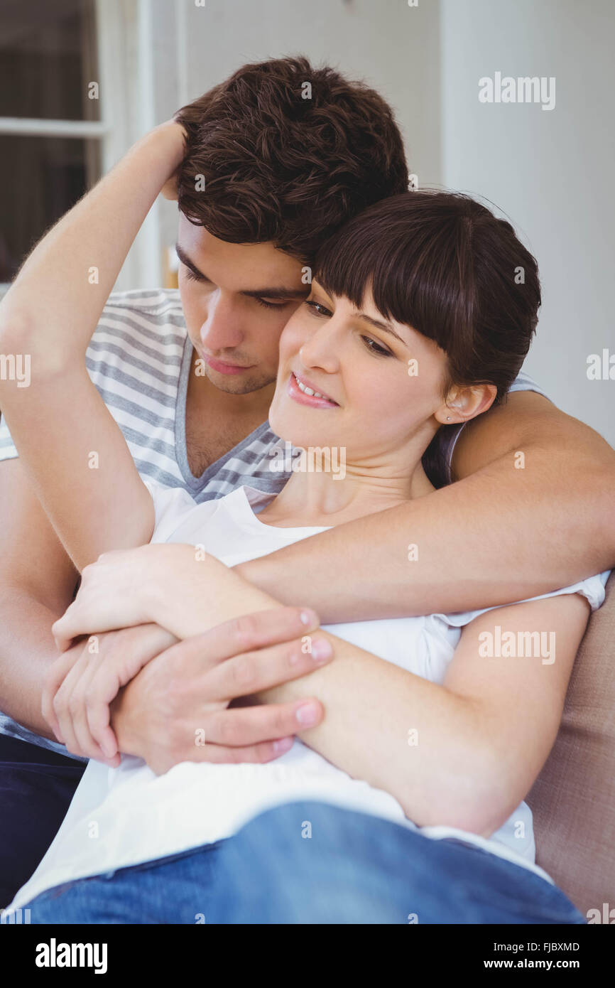 Young couple cuddling on sofa Stock Photo