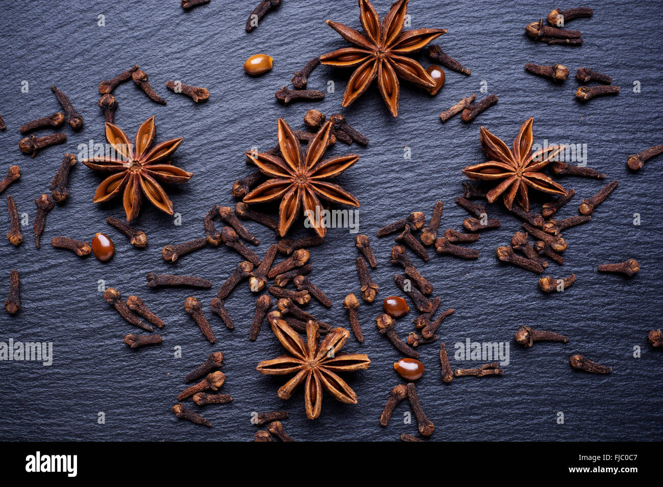Vintage photo, Star of anise and cloves lying on dark table, seasoning for cooking, baking Stock Photo