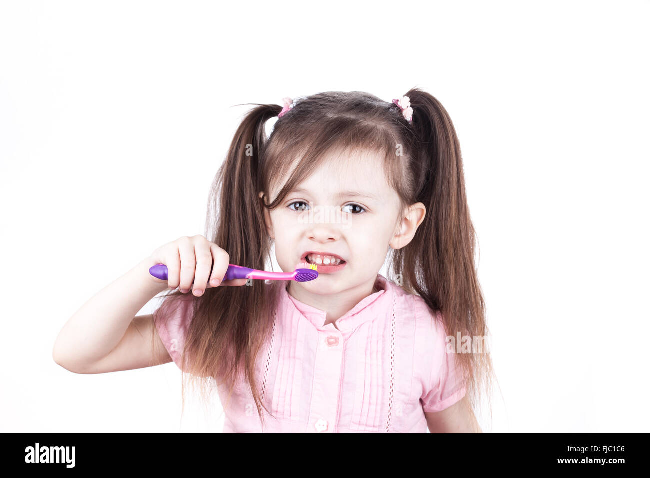 little child brushes her teeth, isolated on a white background Stock Photo