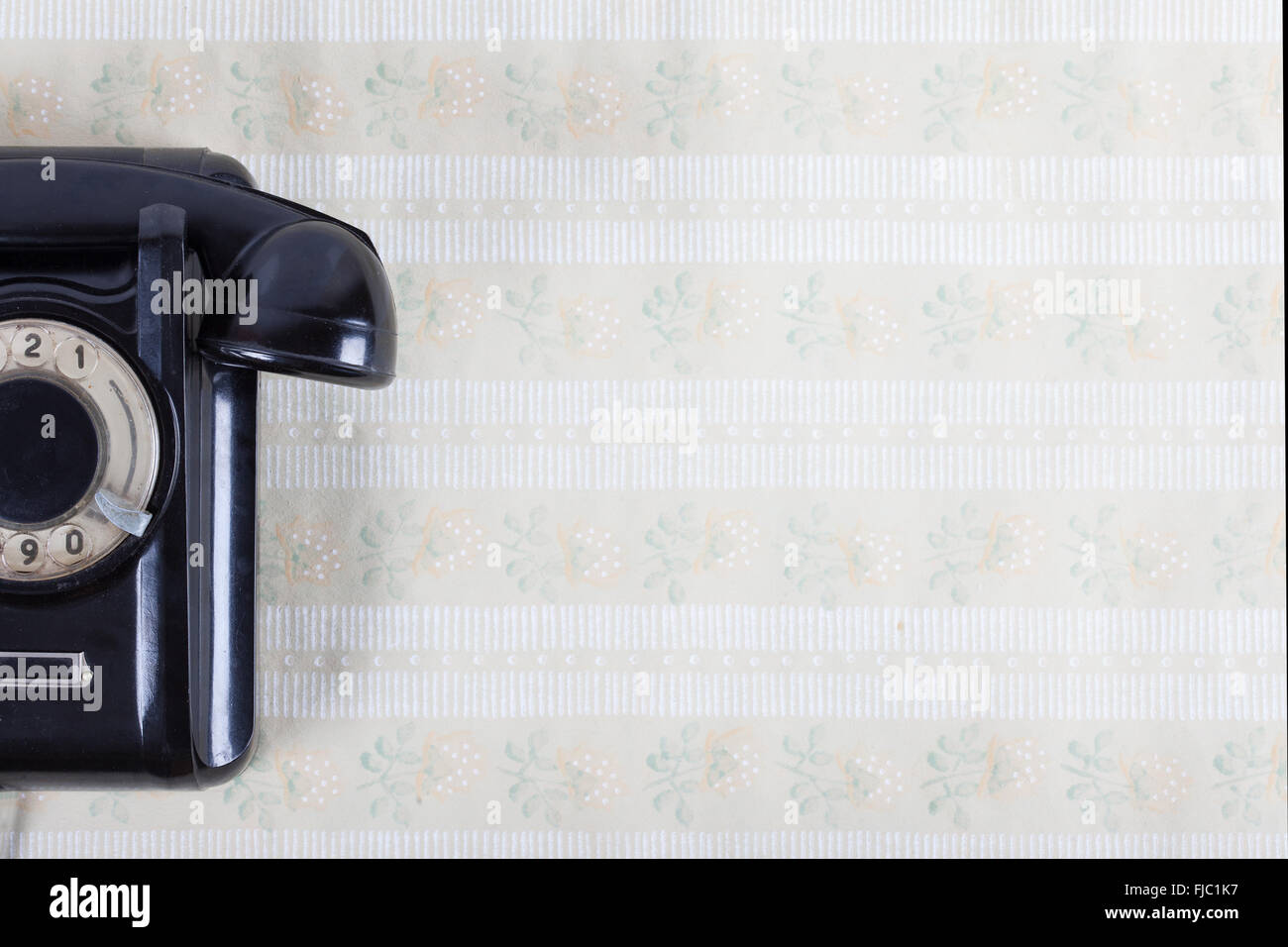vintage phone on the wall with retro wallpaper Stock Photo