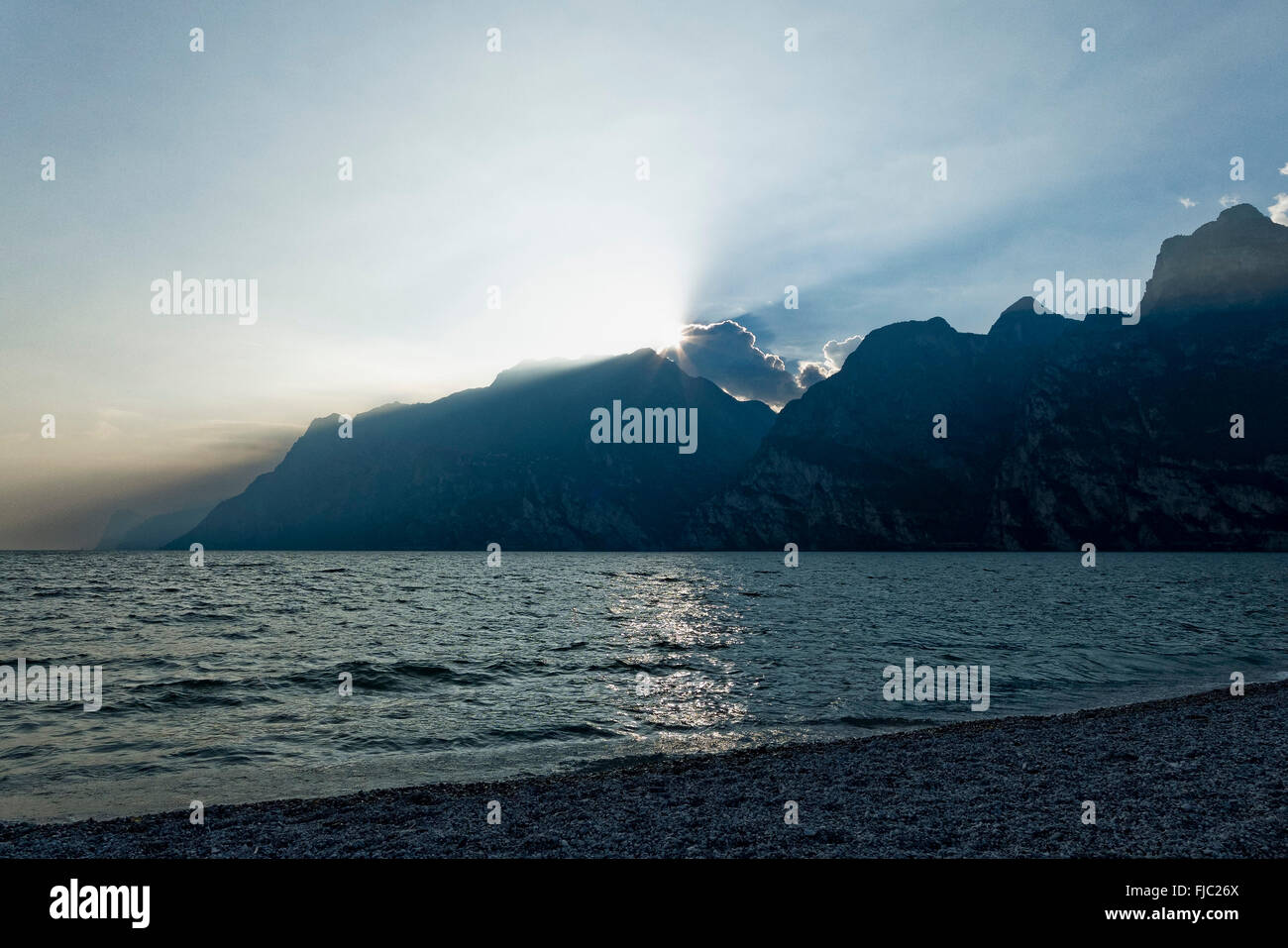 Beach, sun over the mountains, Torbole, Lake Garda, Trentino, Italy Stock Photo