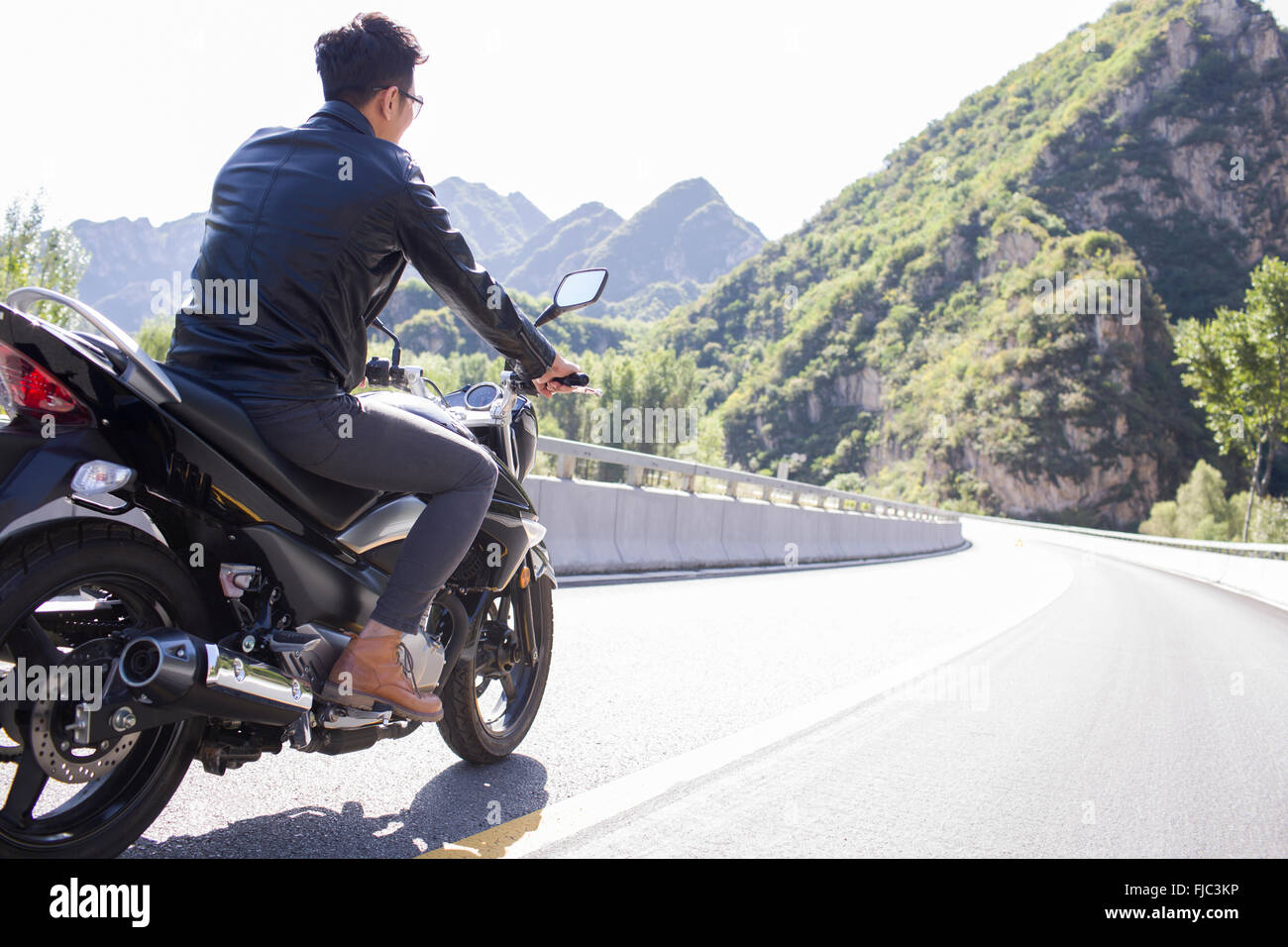 Young Chinese man riding motorcycle Stock Photo