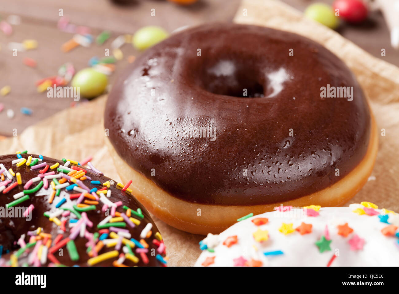 Donuts and candies on wooden table Stock Photo