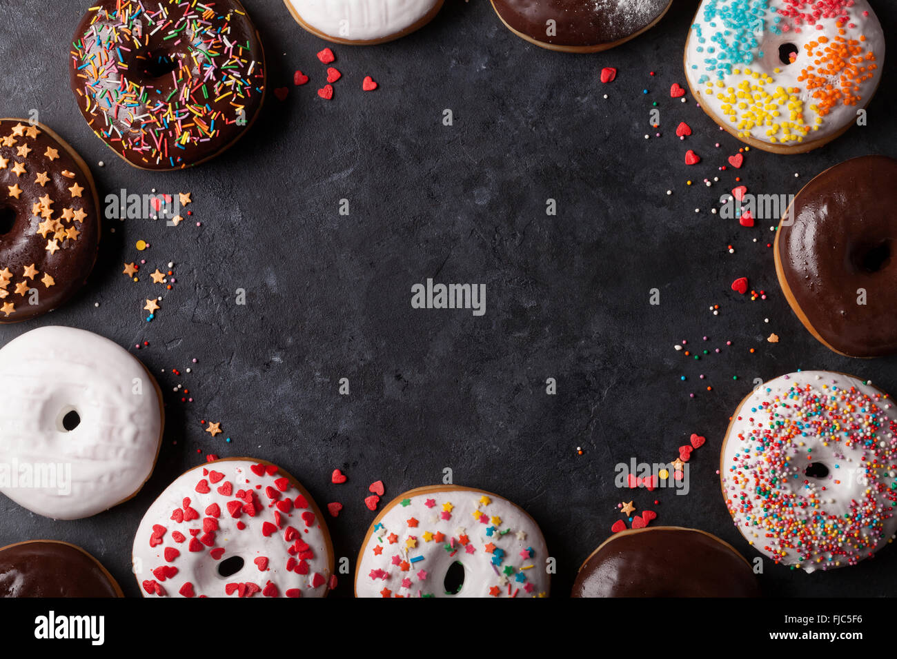 Colorful donuts on stone table. Top view with copy space Stock Photo ...