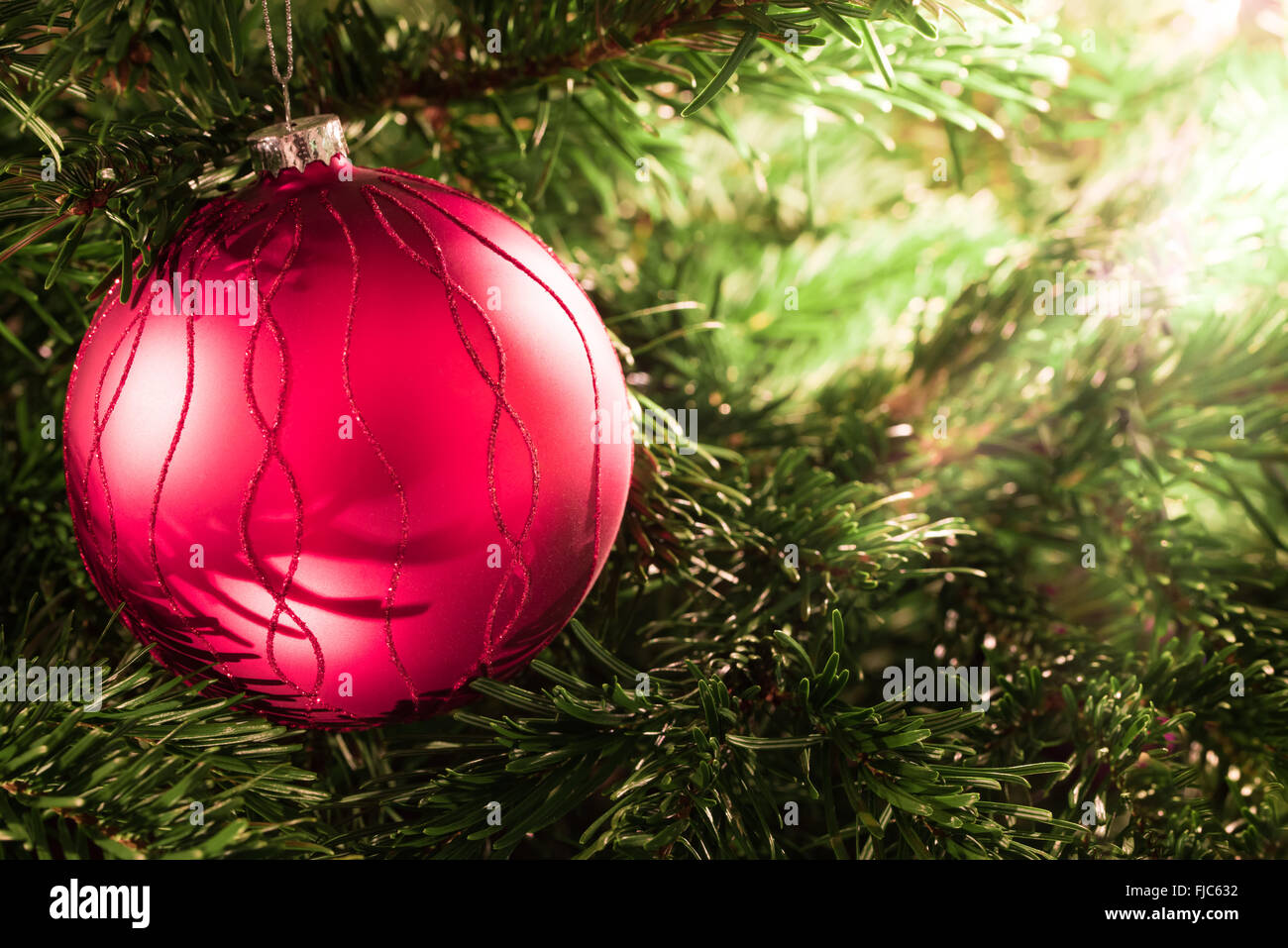 Red Christmas ball on the Christmas tree in the candlelight Stock Photo