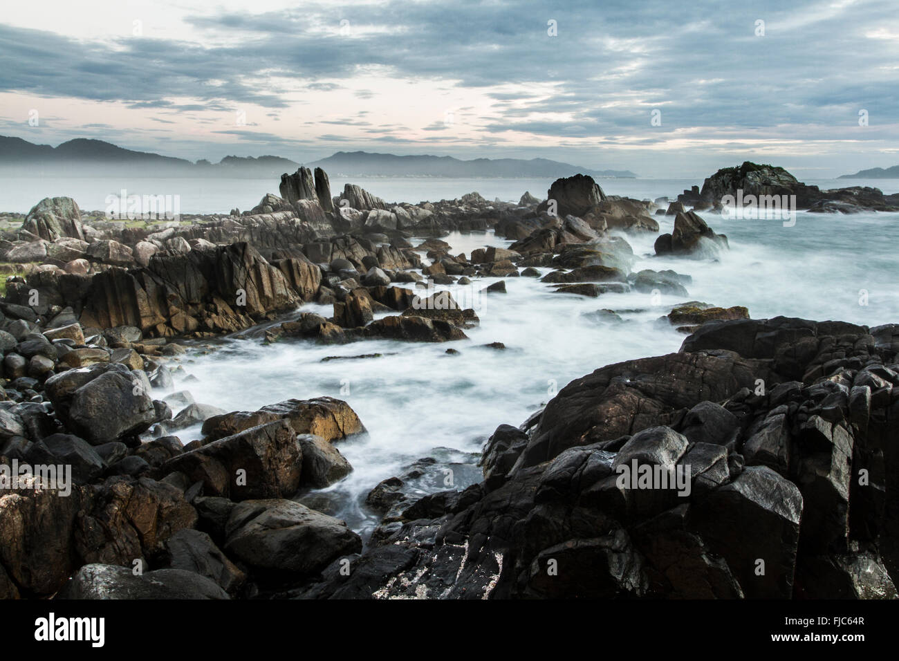 Rocky shore of Campanhas Island, at Armacao Beach, at sunrise. Florianopolis, Santa Catarina, Brazil. Stock Photo