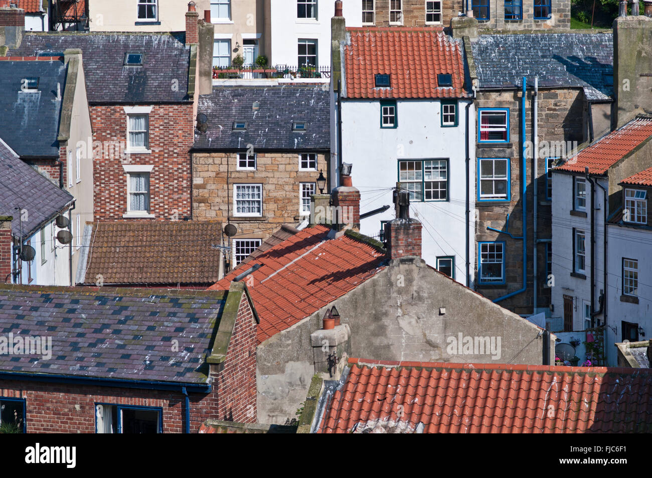 Close-up view of stone built terraces with grey slate and red pantiled roofs built on the hillside in Staithes, North Yorkshire Stock Photo