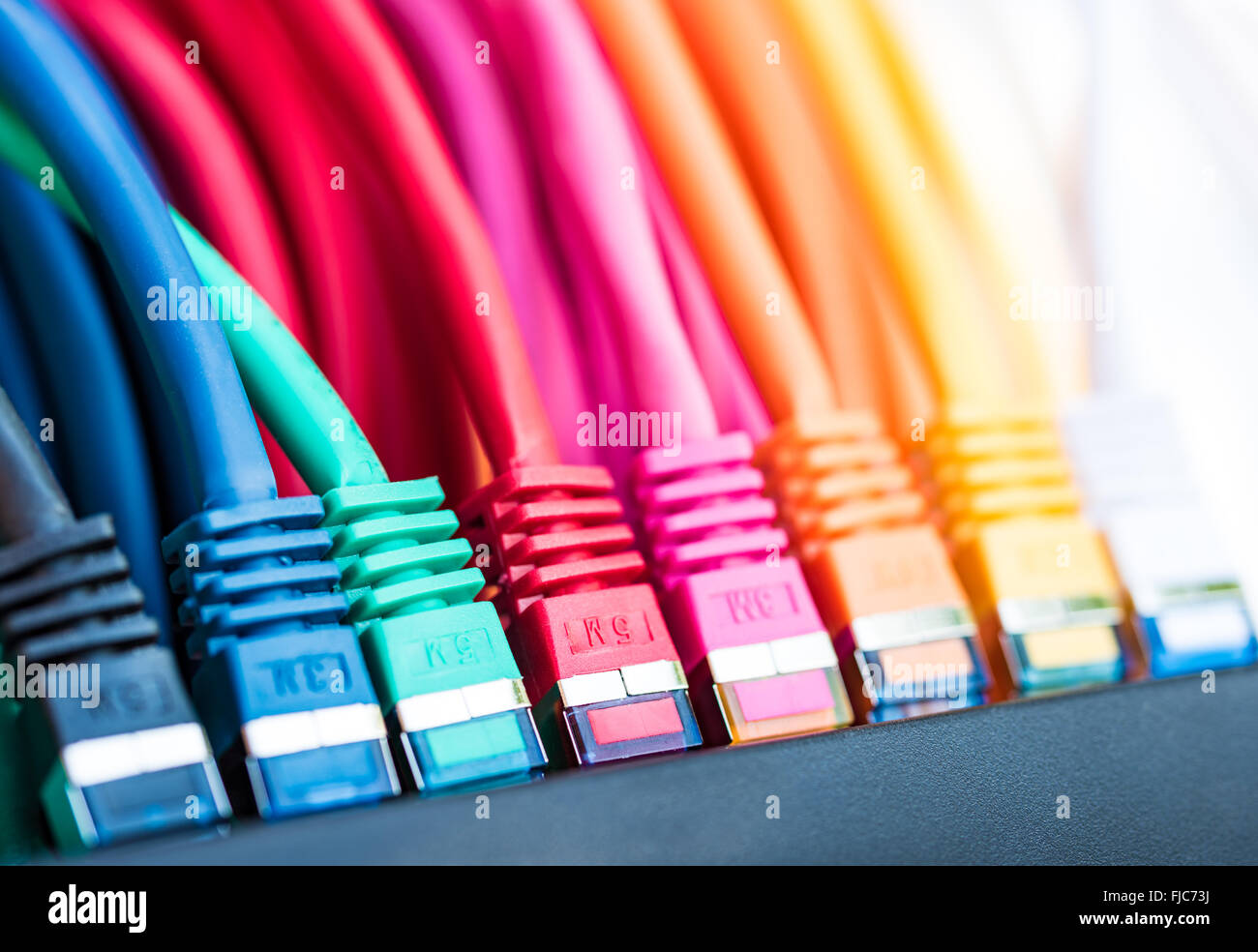 Colorful network cables connected to a switch Stock Photo