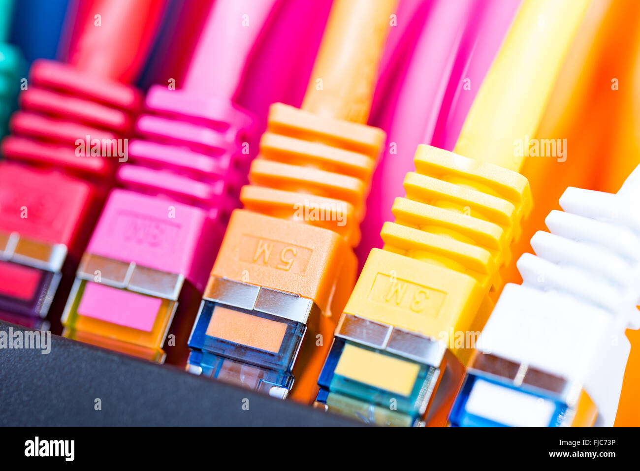 Colorful network cables connected to a switch Stock Photo