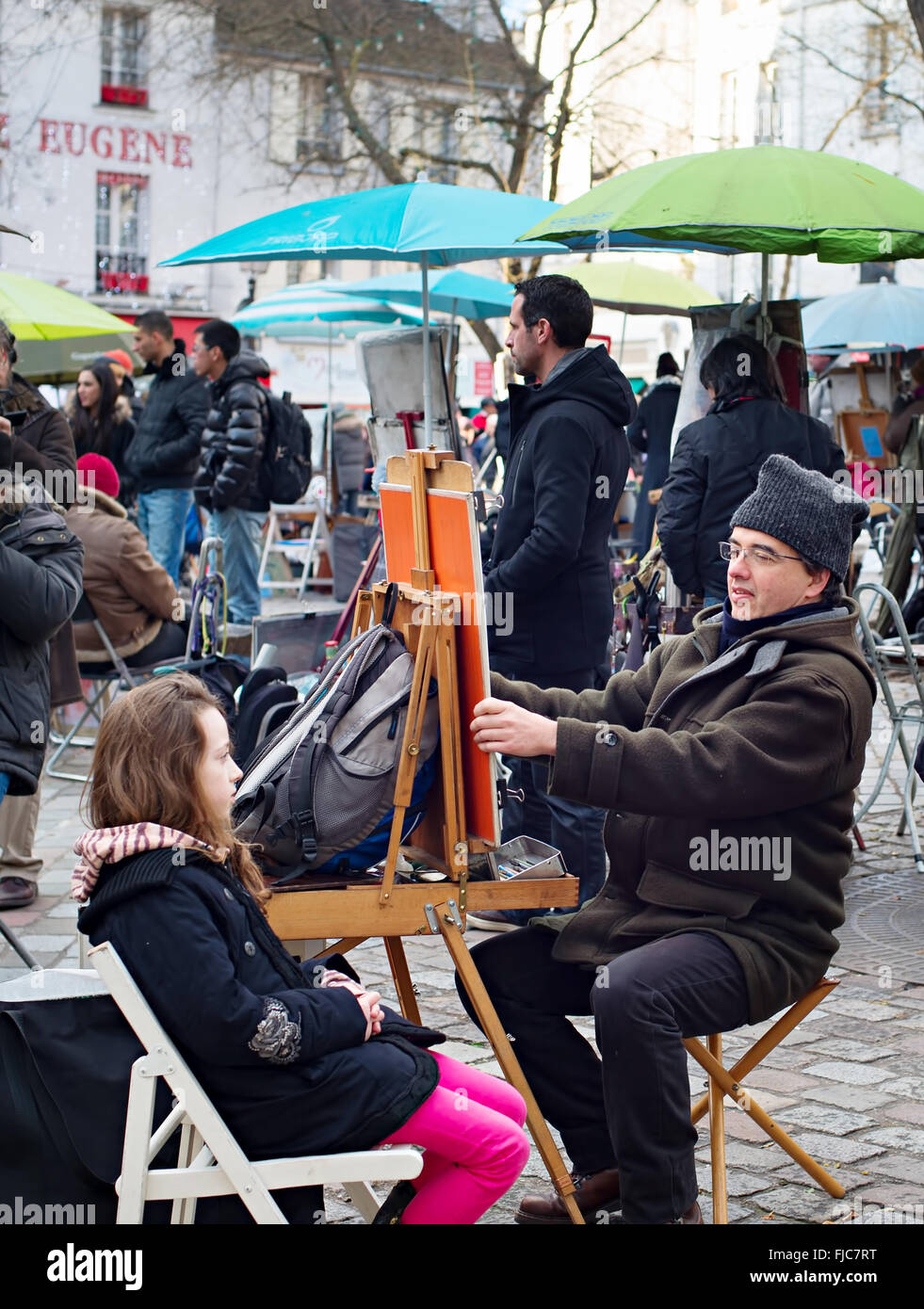 Unidentified artist drawing a portrait of the tourist at Place du Tertre, Montmartre. Place du Ter Stock Photo