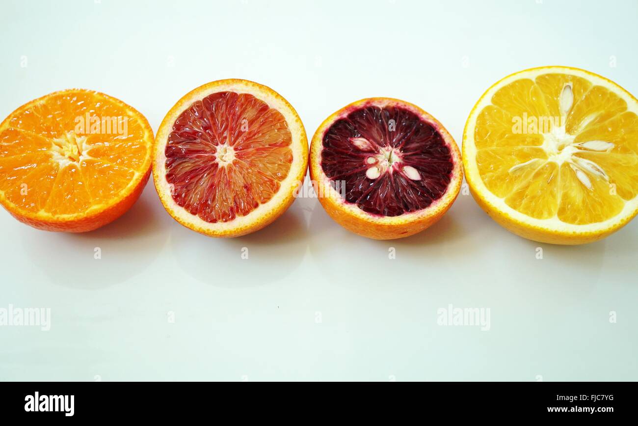 Ruby red blood oranges, navel oranges, and clementines cut in half on a
