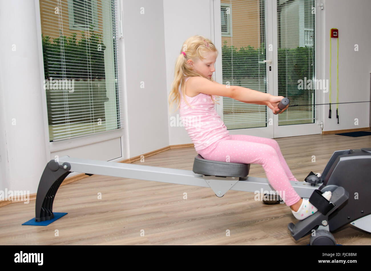 little blond girl doing exercise in the gym Stock Photo - Alamy