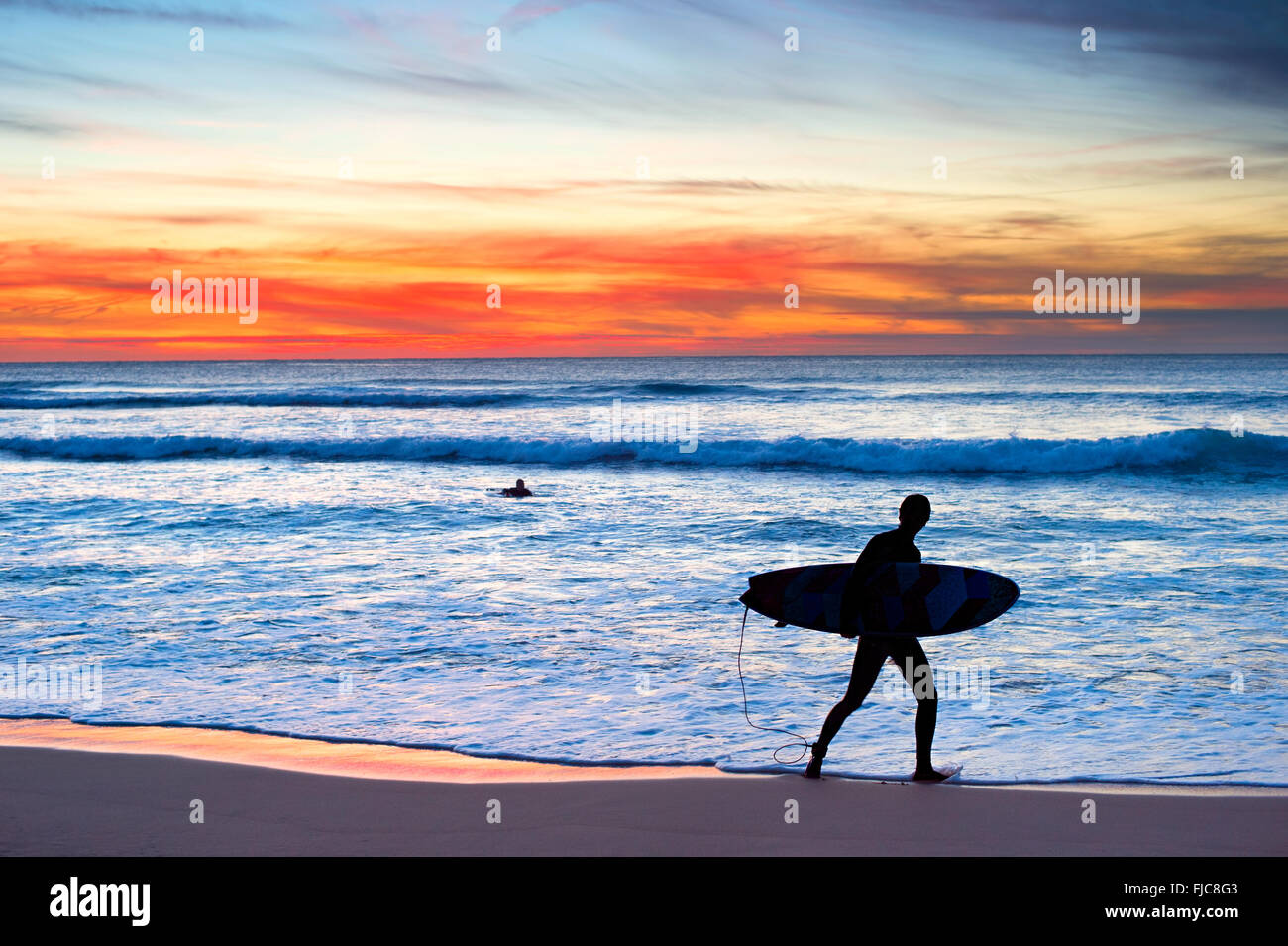 Silhouette of a surfer on the beach at a beautiful sunset Stock Photo ...