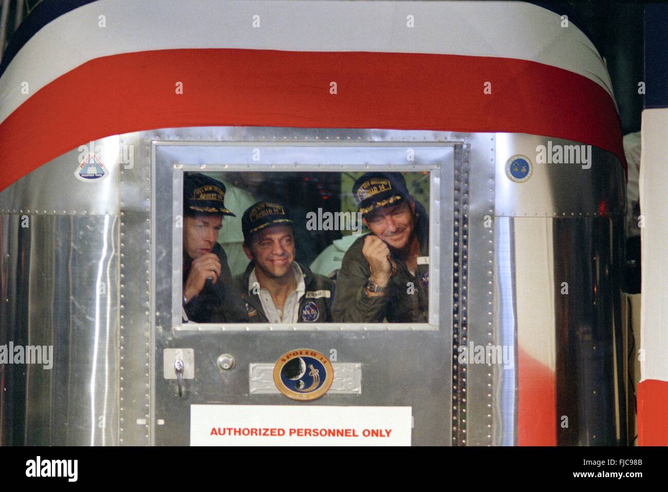 NASA Apollo 14 astronauts sealed inside a Mobile Quarantine Facility after returning to earth in the Apollo 14 spacecraft February 9, 1971 aboard the USS New Orleans. Left to Right: Astronauts Stuart A. Roosa, Alan B. Shepard Jr., and Edgar D. Mitchell. Stock Photo