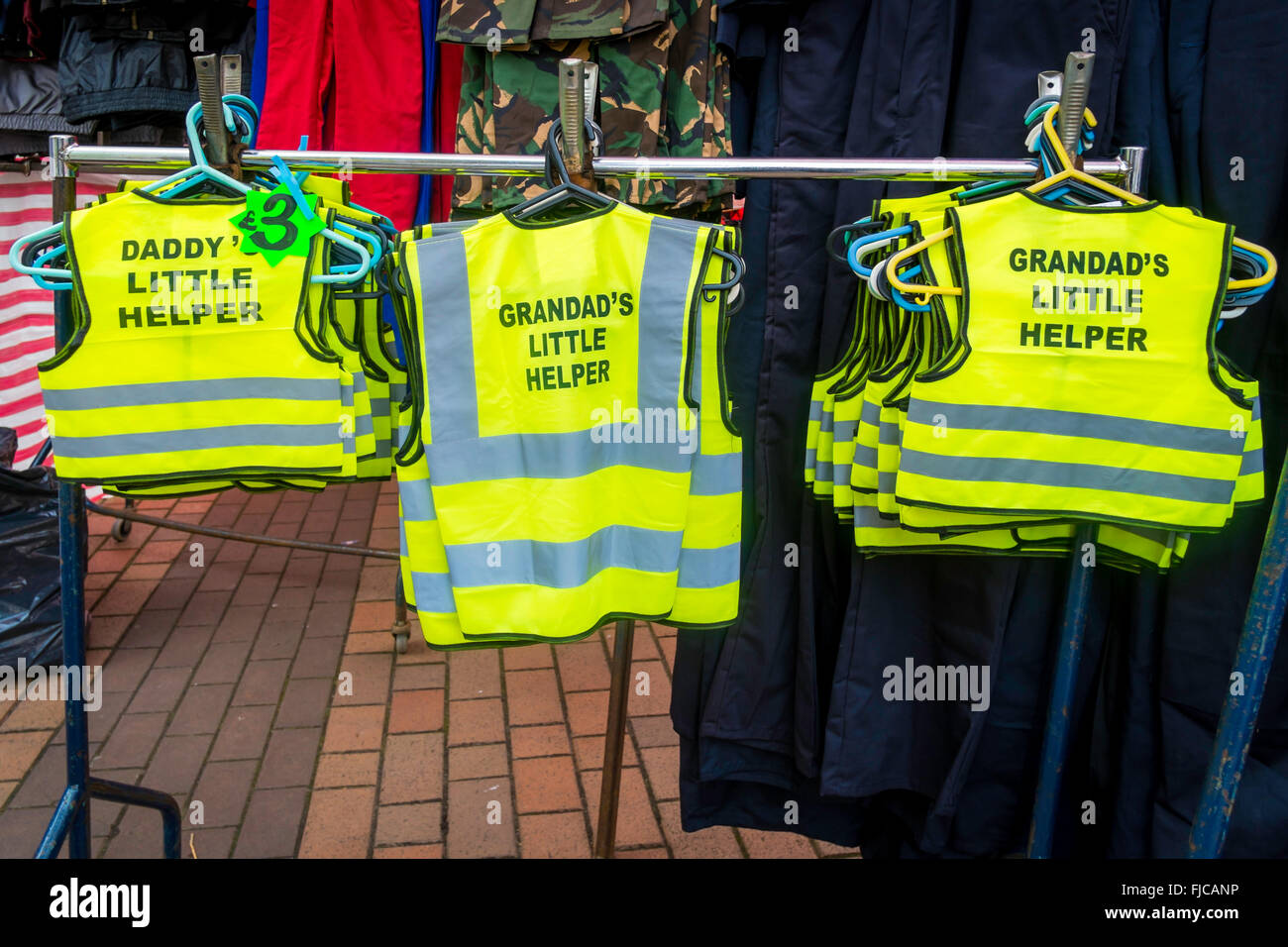 Road Safety Childs High Visibility Tabards for sale on a market stall with text Daddies little helper or Grandad's little helper Stock Photo