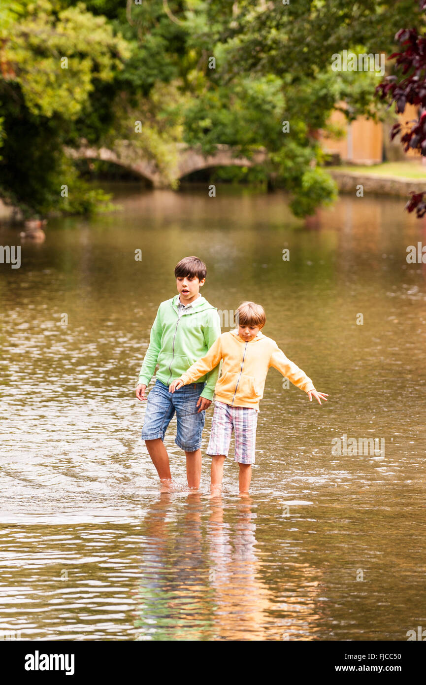 Children playing at Bourton-On-The-Water in Gloucestershire , England , Britain , Uk Stock Photo