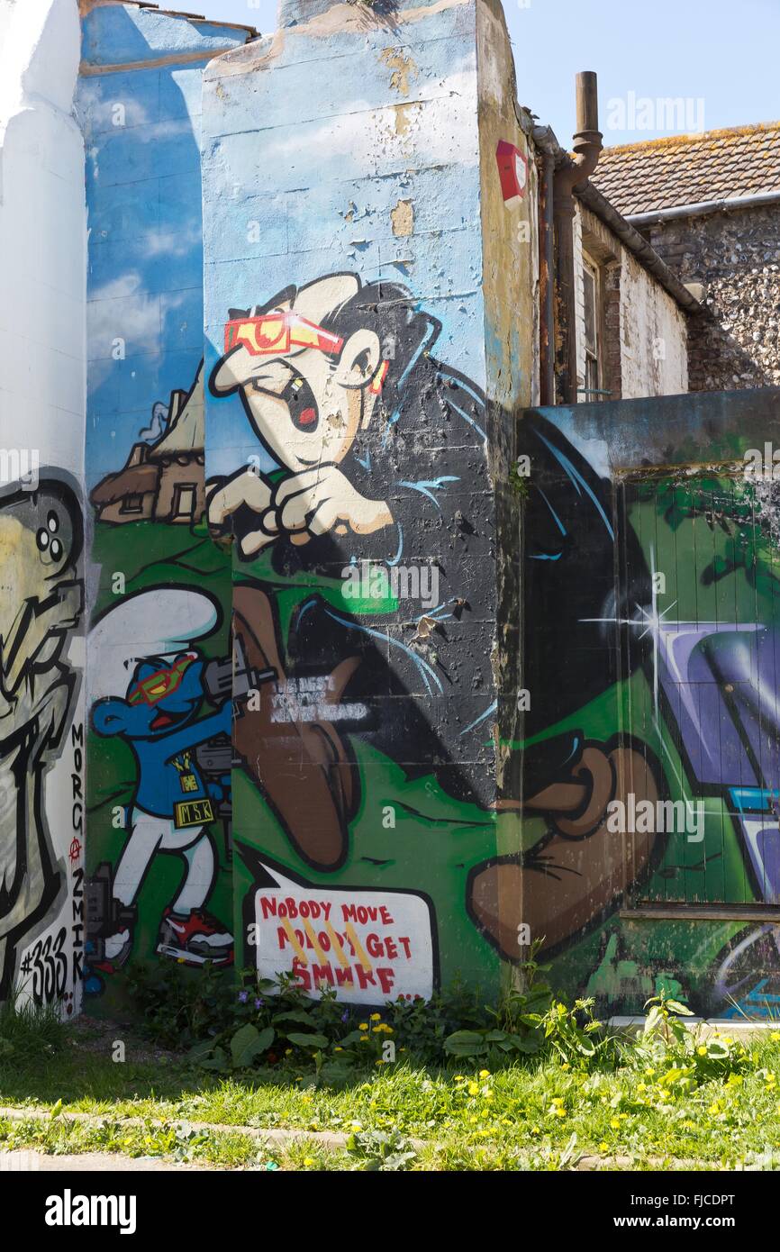 A graffiti of the smurphs and Gargamel spray painted on a wall of a brick house with a blue sky Stock Photo