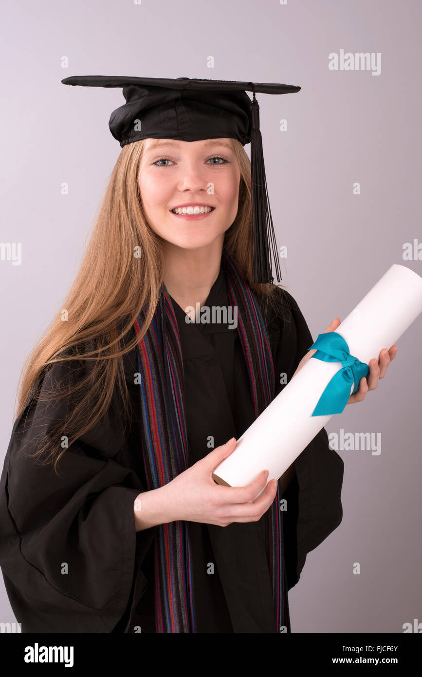 Young graduate in cap and gown with diploma Stock Photo Alamy