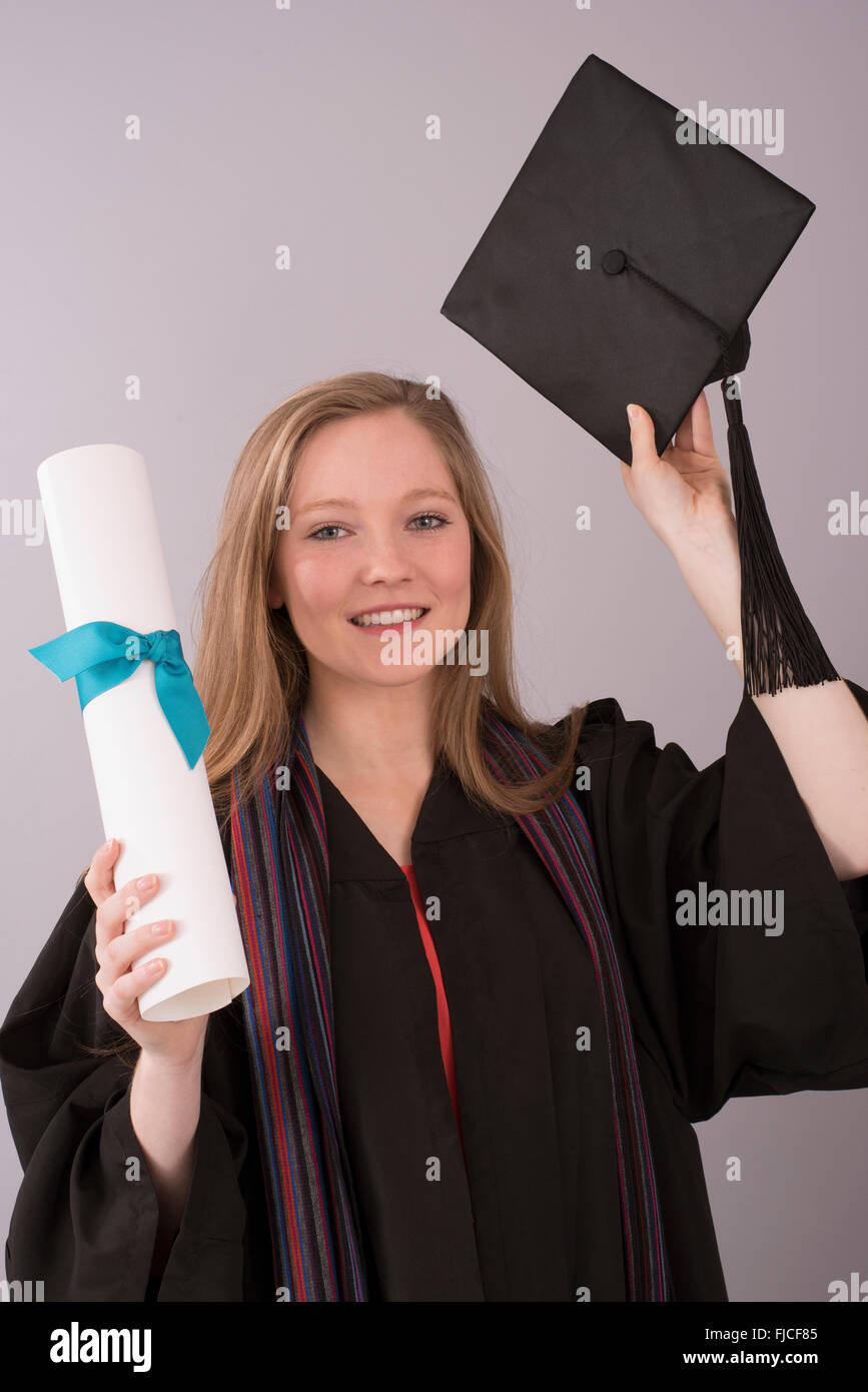 Young graduate in cap and gown with diploma Stock Photo