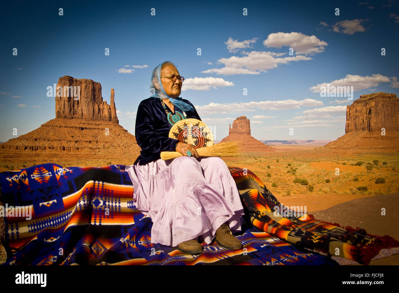 Navajo Indian woman in traditional dress sitting on Navajo Blanket