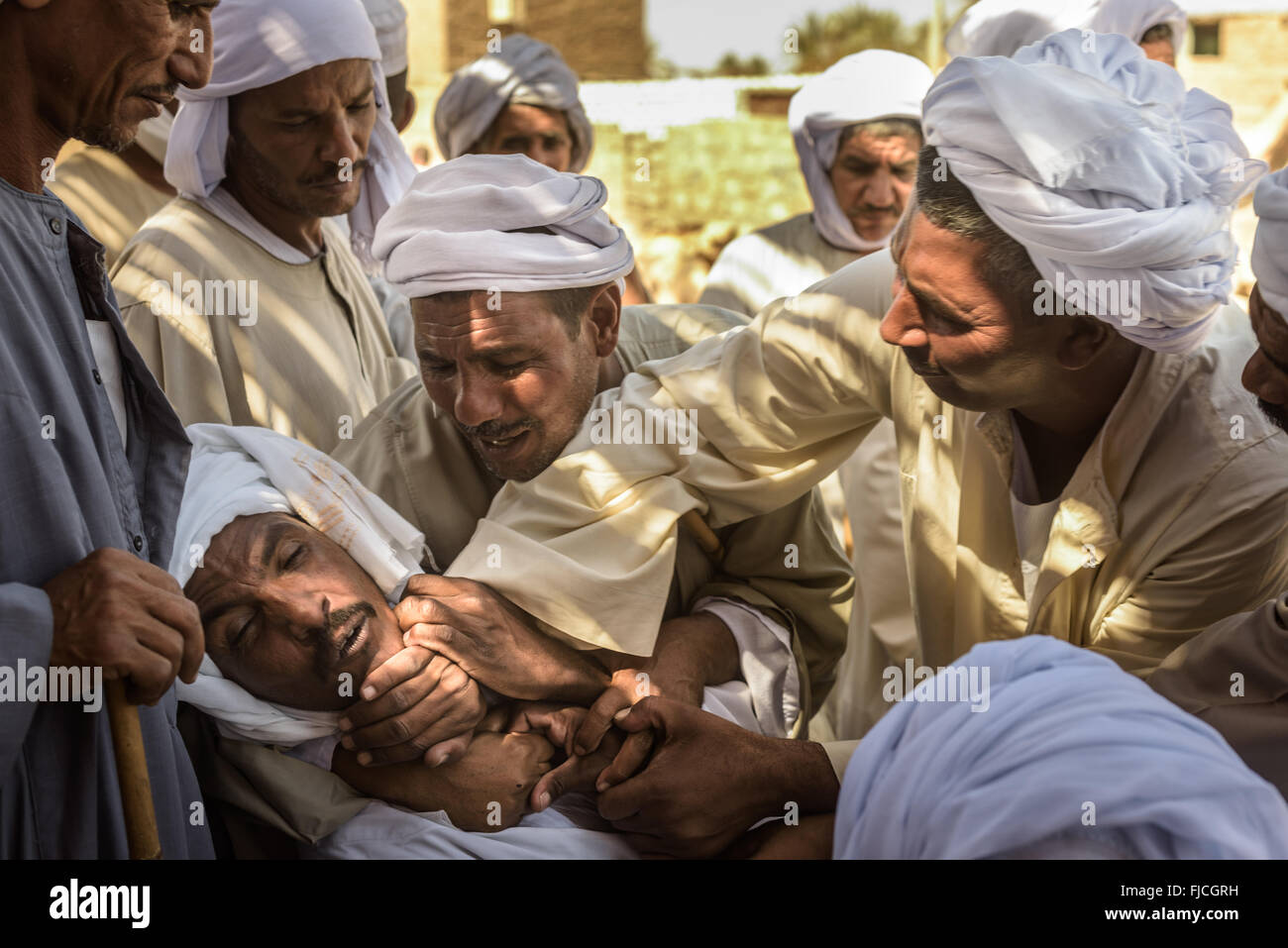 Group of camel herders and buyers bargaining hard to agree on the final price of camels during a camel market. Stock Photo