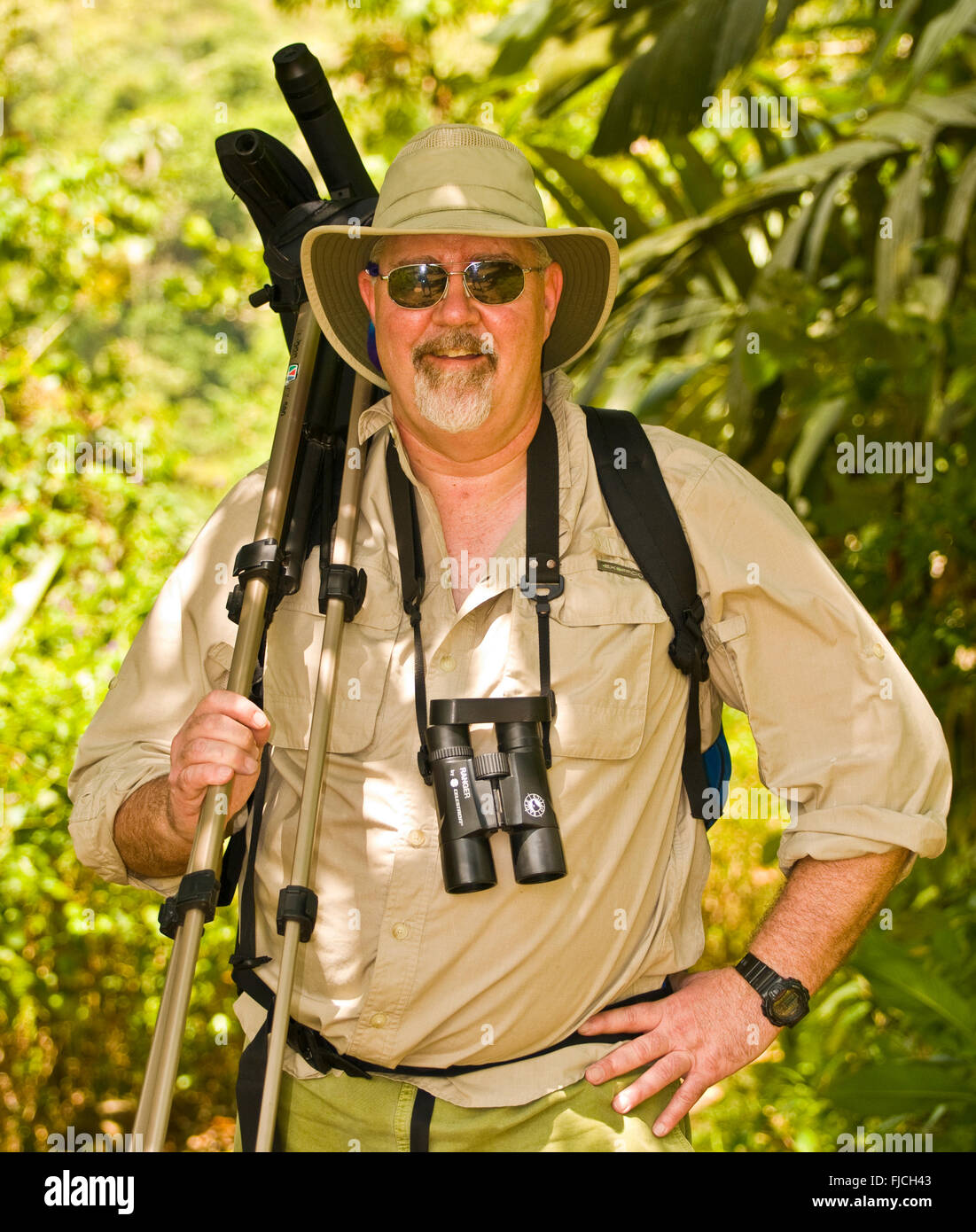 Wildlife watchintg, Man with binoculars birding in rainforest jungle. Costa Rica Stock Photo