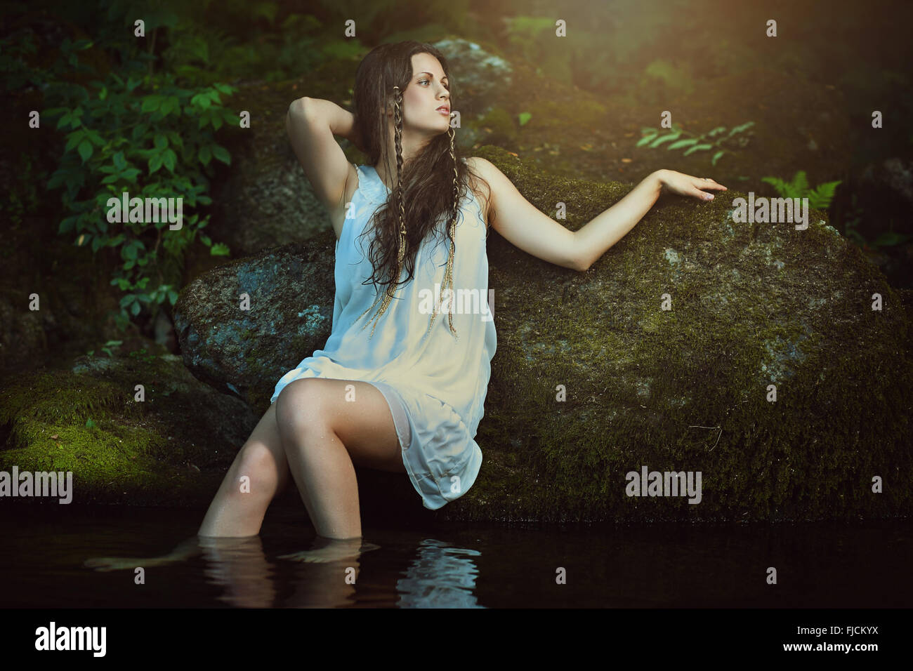 Beautiful nymph of the waters  posing in forest stream . Fantasy and surreal Stock Photo
