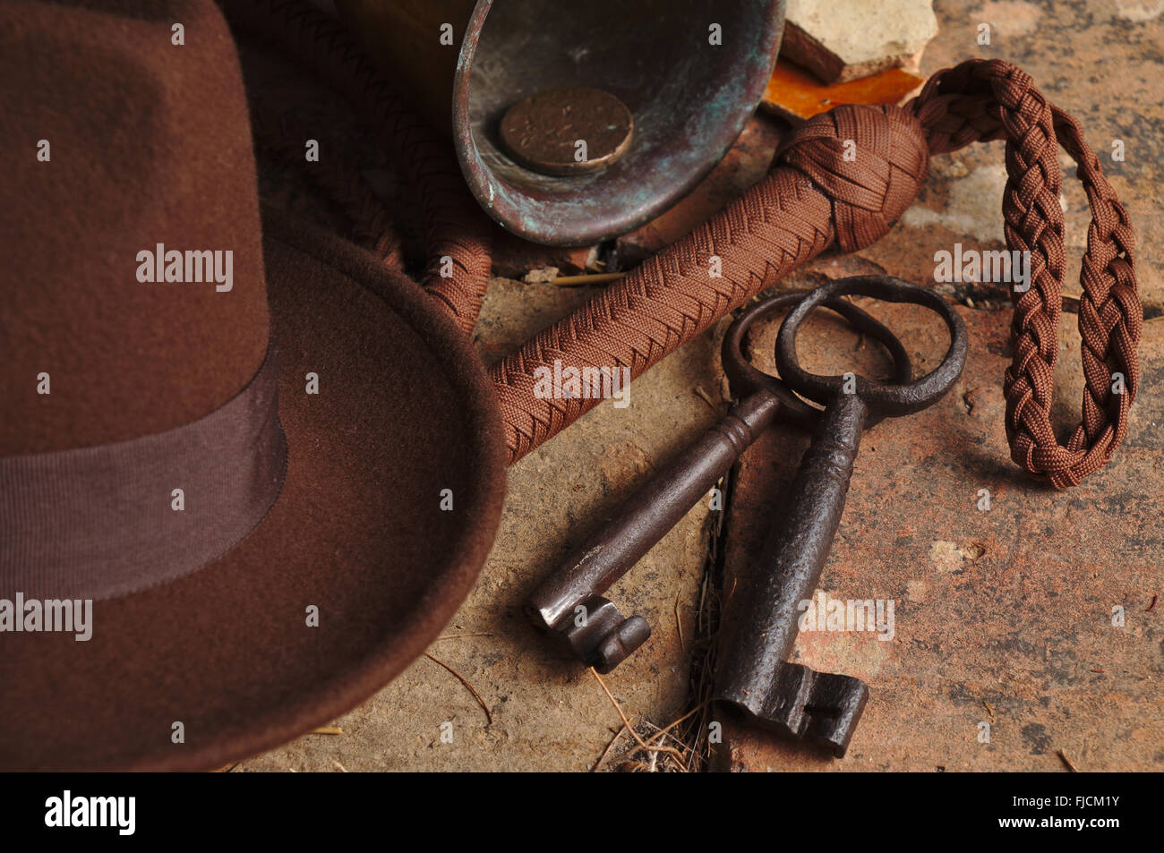 Indiana Jones related items: Fedora hat, whip, knife, antique skeleton keys and other artifacts. Themed photography Stock Photo