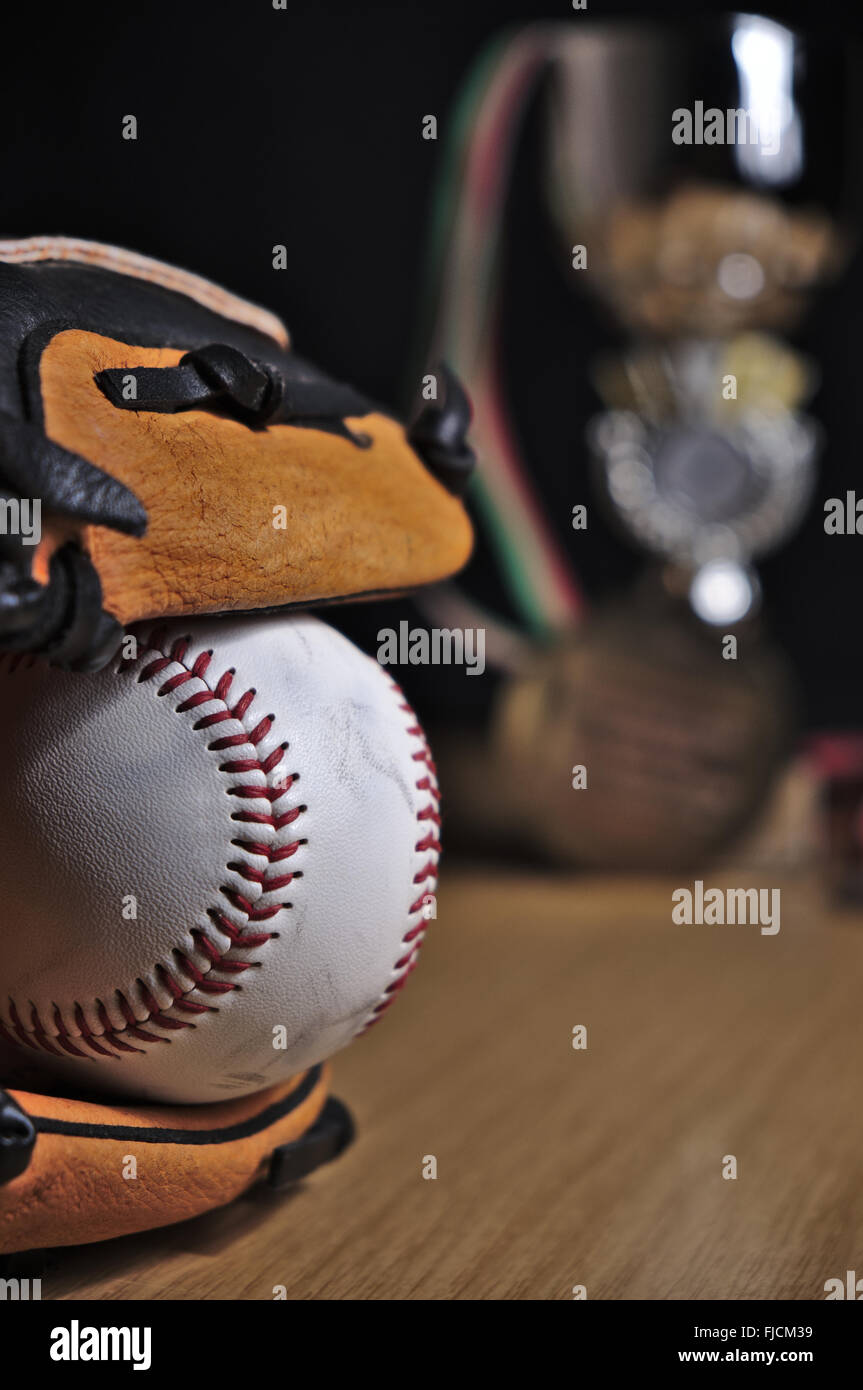 Close-up of a Baseball leather glove and ball on a wooden surface. Baseball themed photograph Stock Photo