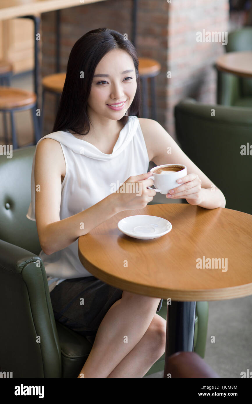 Young Chinese woman drinking coffee in café Stock Photo Alamy