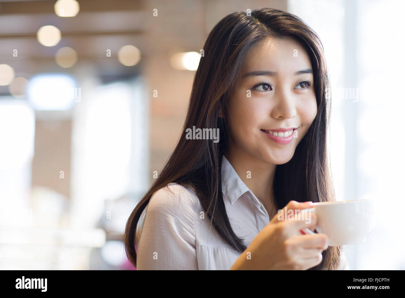 Young Chinese woman drinking coffee in café Stock Photo - Alamy