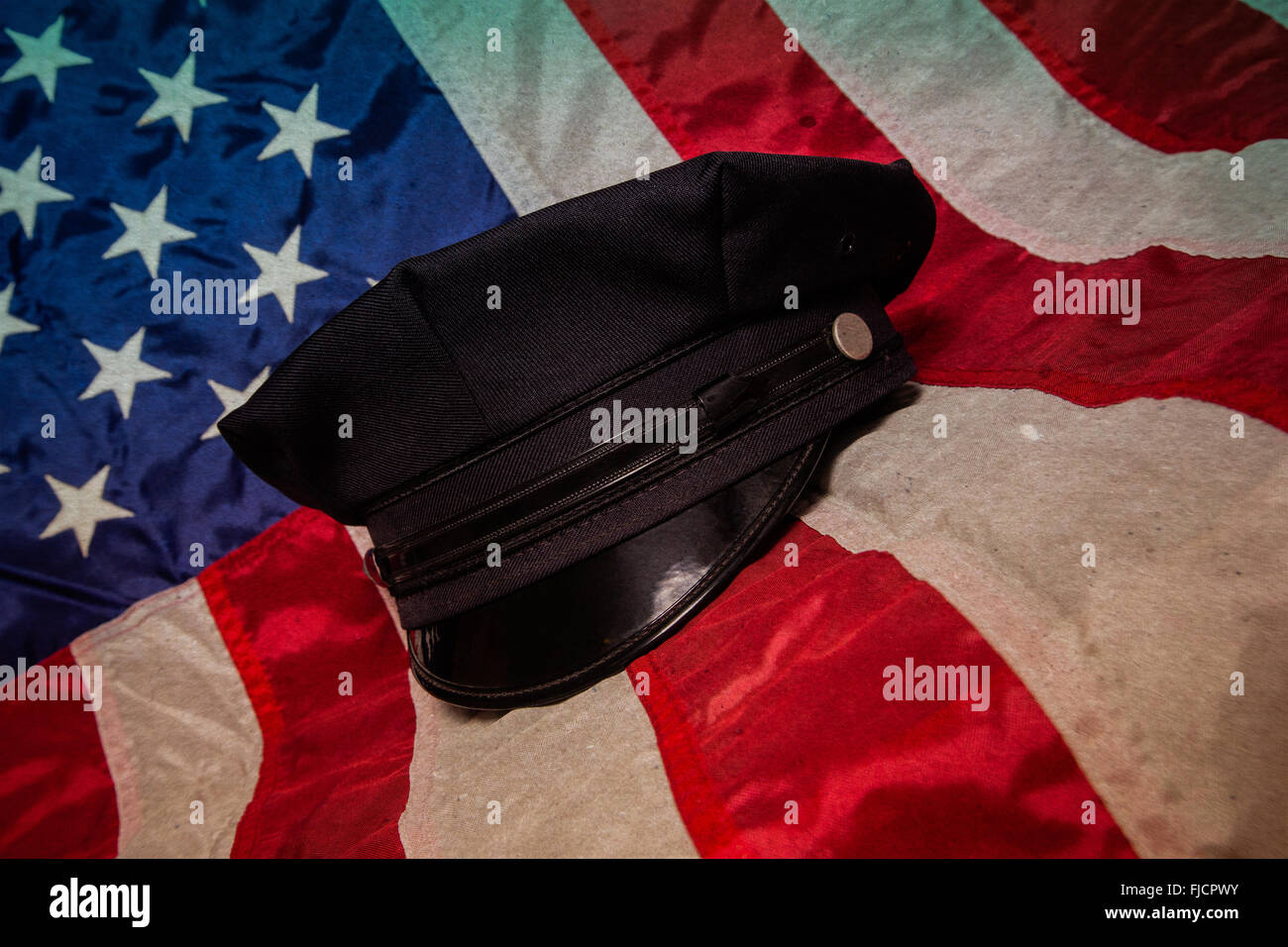 A police hat on an American flag background. Stock Photo