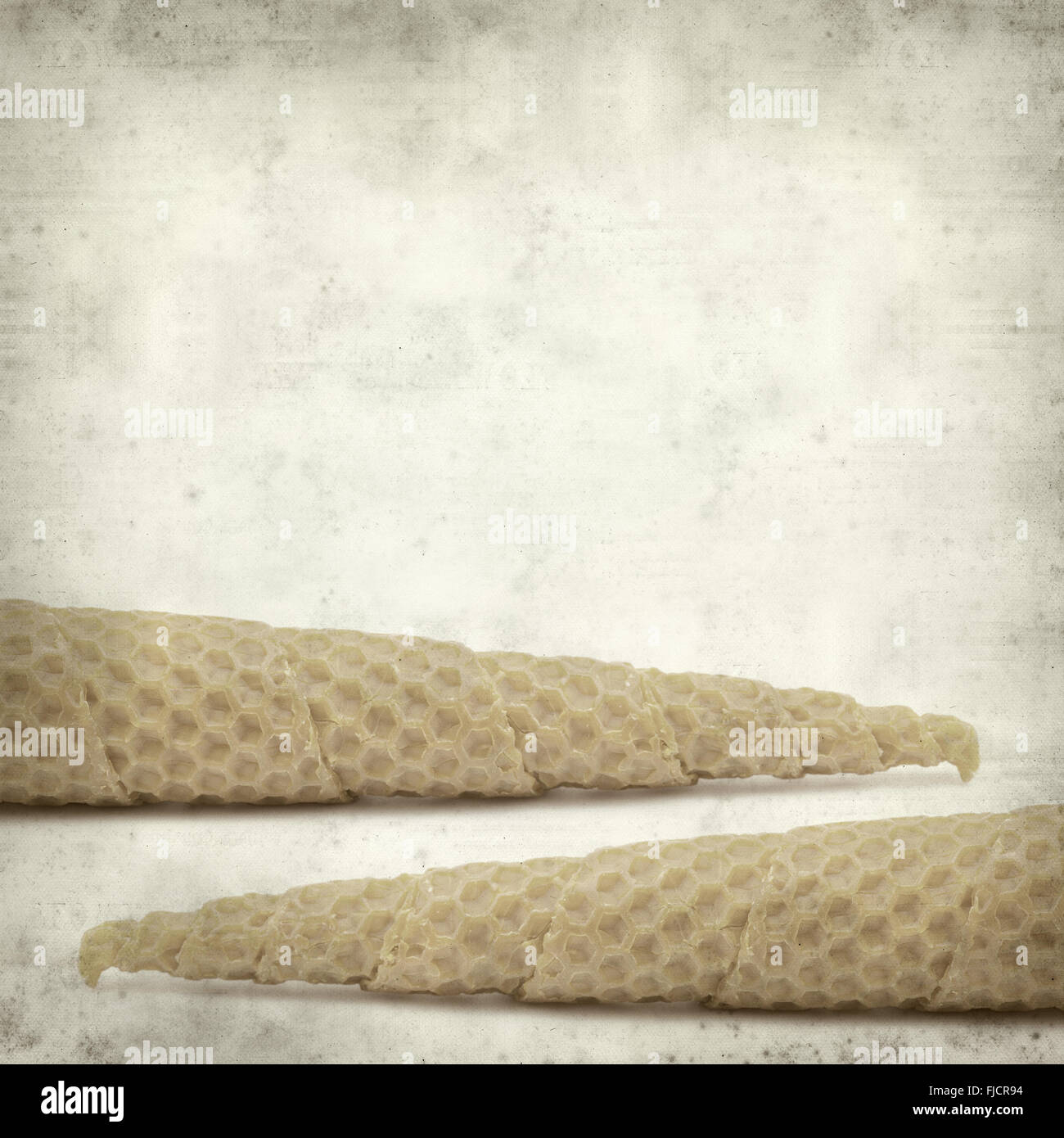 textured old paper background with wrapped beeswax candle Stock Photo