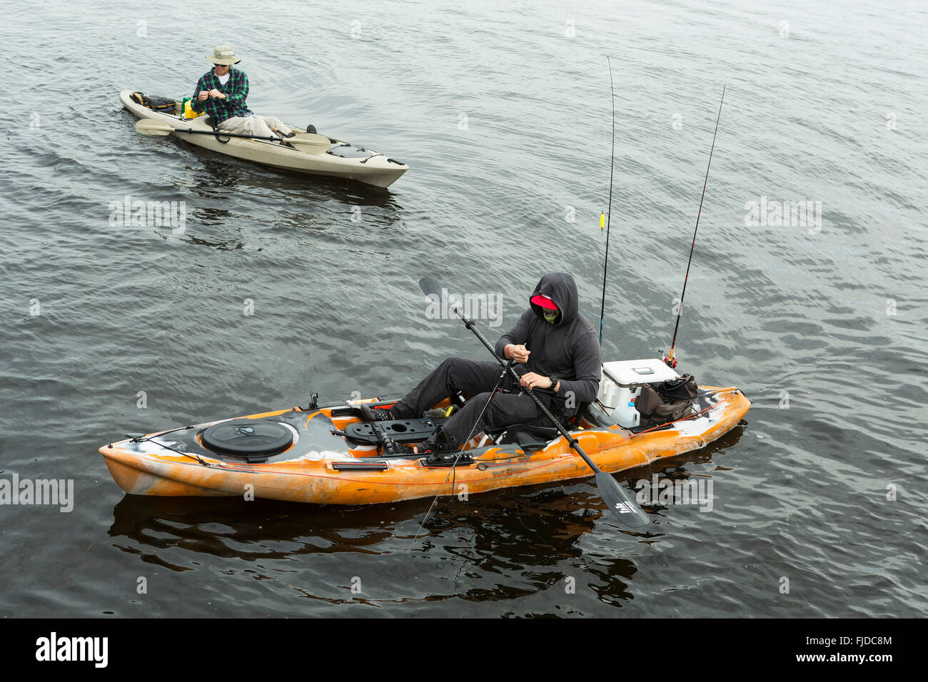 Men in two kayaks for fish in the sea, fishing from a kayak in a gloomy day at sea. Stock Photo