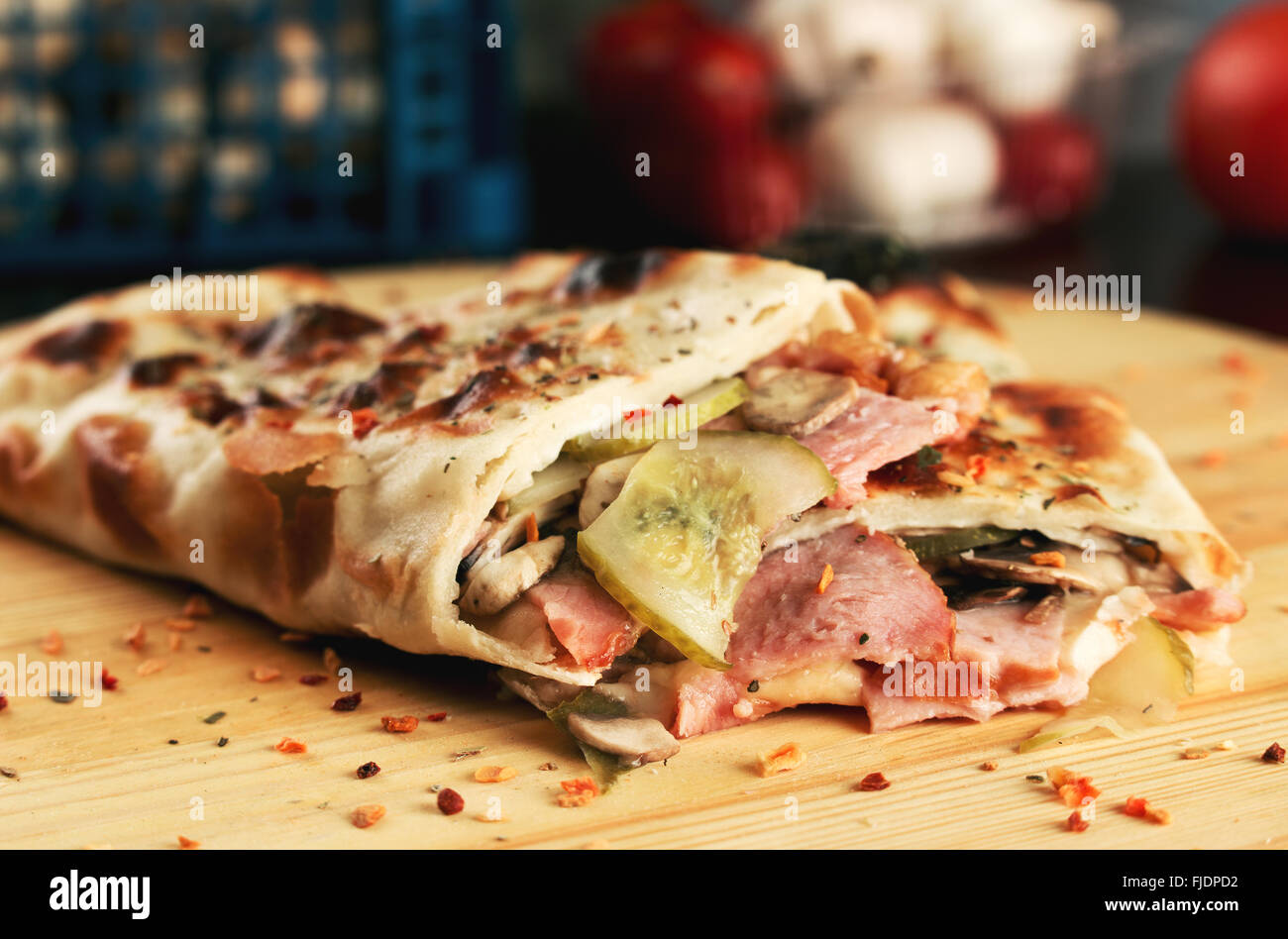 Tasty pizza rolls closed pizza calzone with ham, mushrooms and cucumber. Shallow depth of field Stock Photo